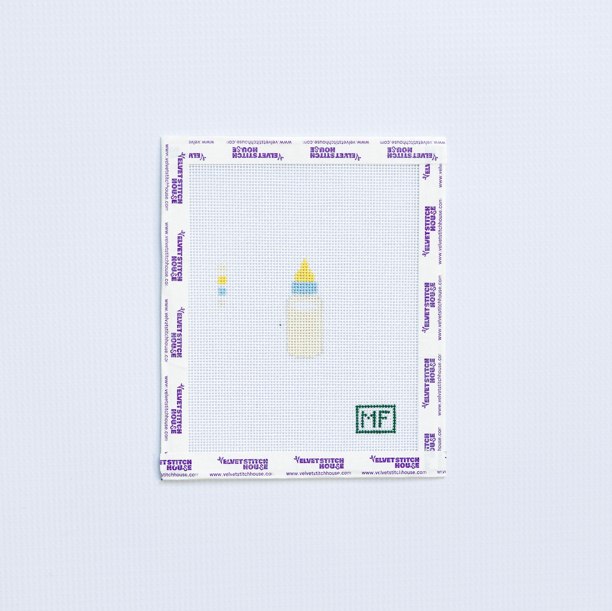 mini needlepoint pattern with cream colored baby bottle 