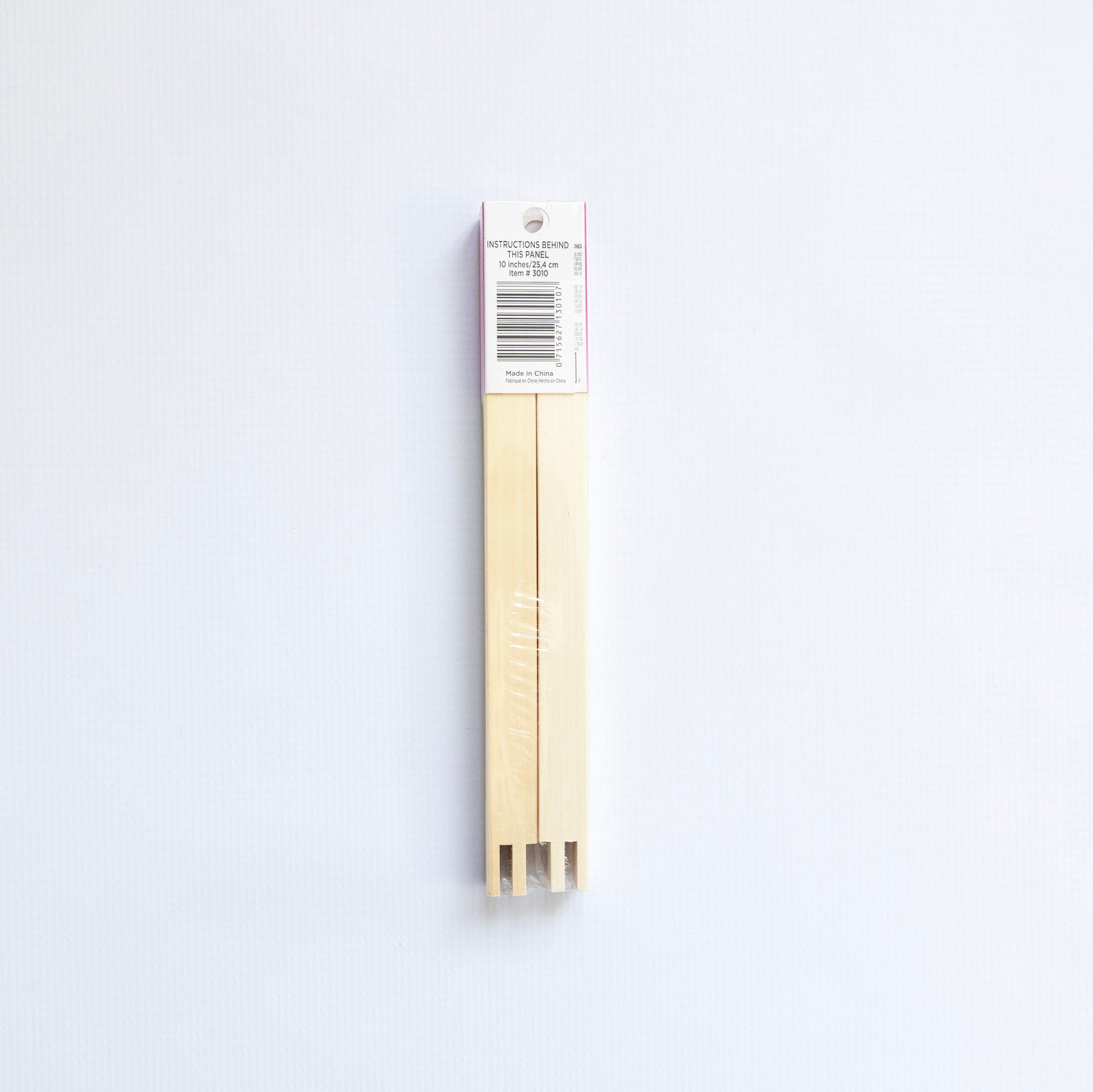 Packaged beige wooden stretcher bars on a white background