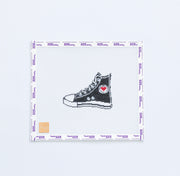 Needlepoint pattern with black high-top sneaker with a red heart on a white background