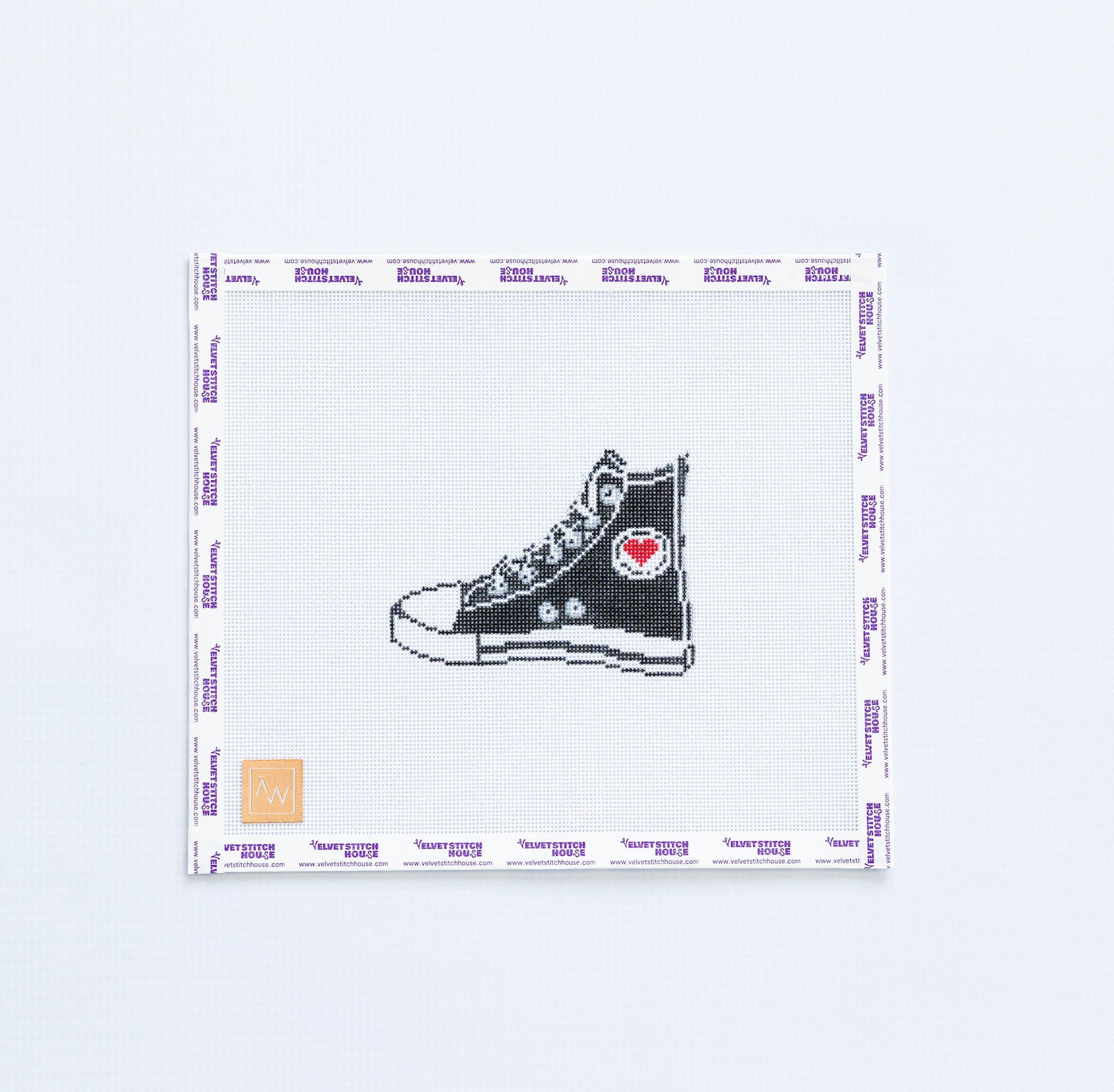 Needlepoint pattern with black high-top sneaker with a red heart on a white background