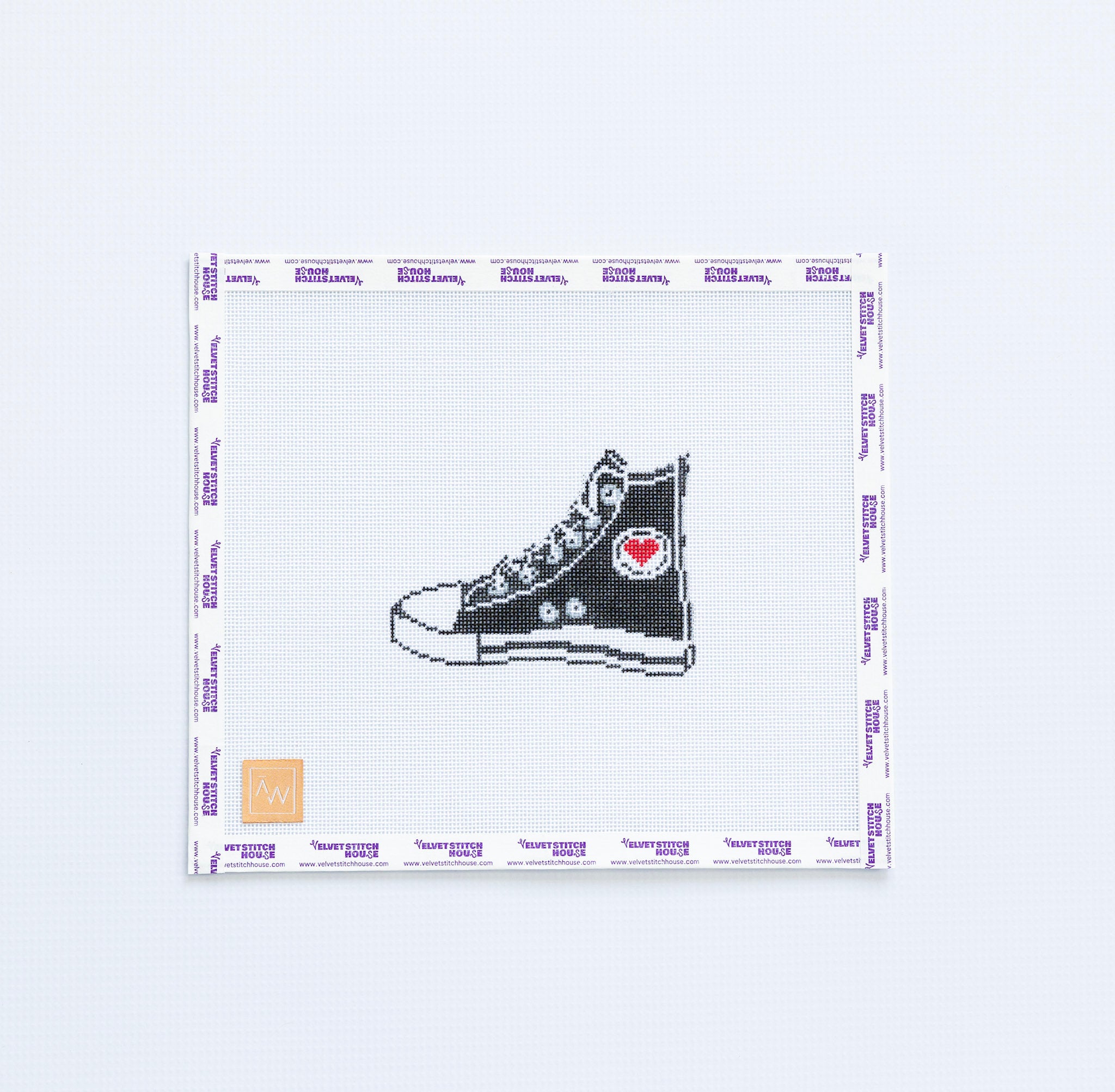 Needlepoint pattern with black high-top sneaker with a red heart on a white background