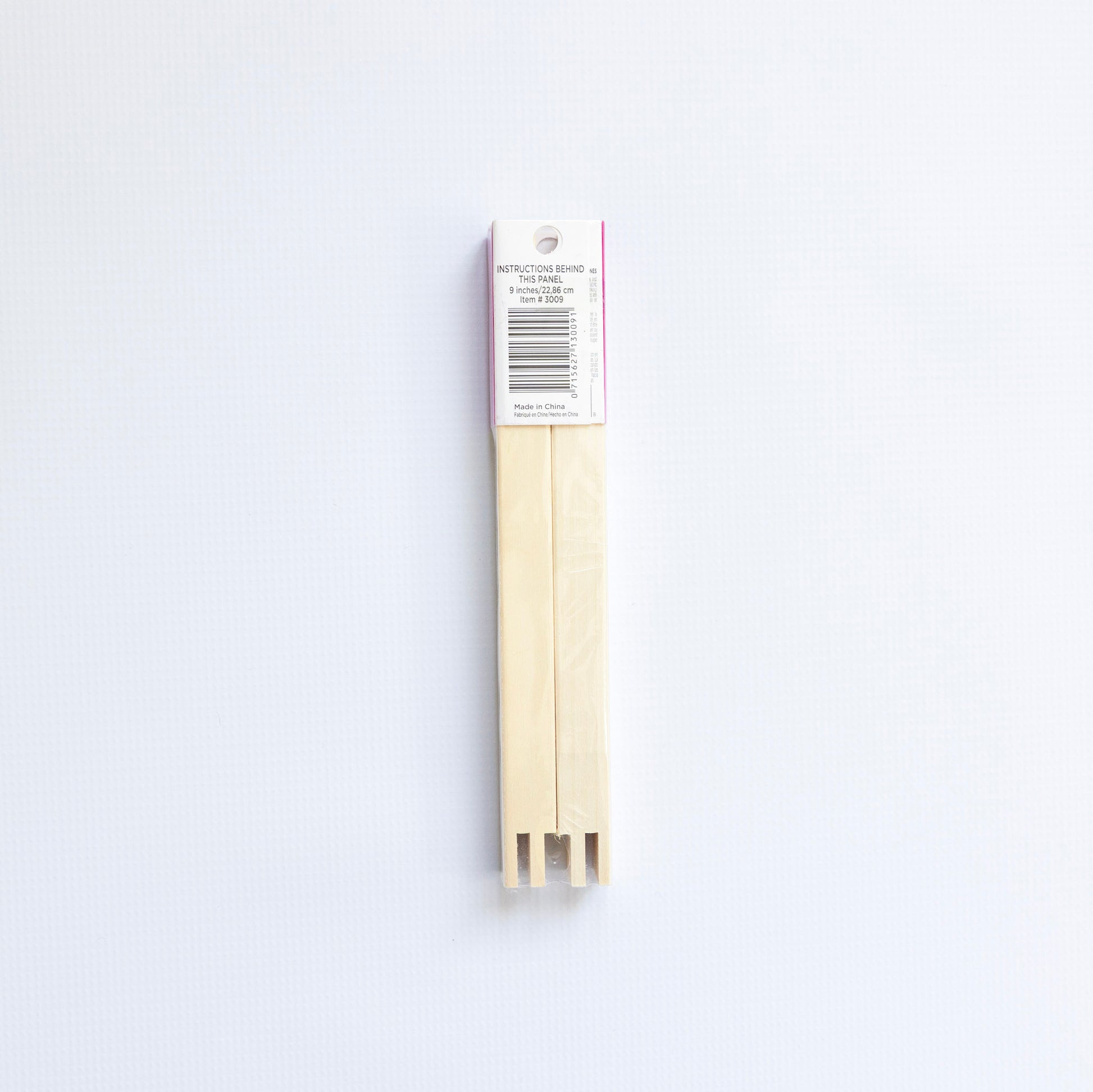 Two wooden skewers with a white label on a light gray background