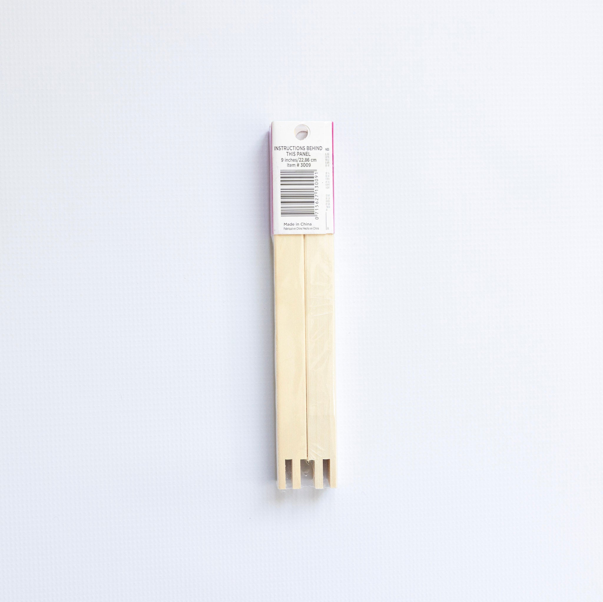 Two wooden skewers with a white label on a light gray background