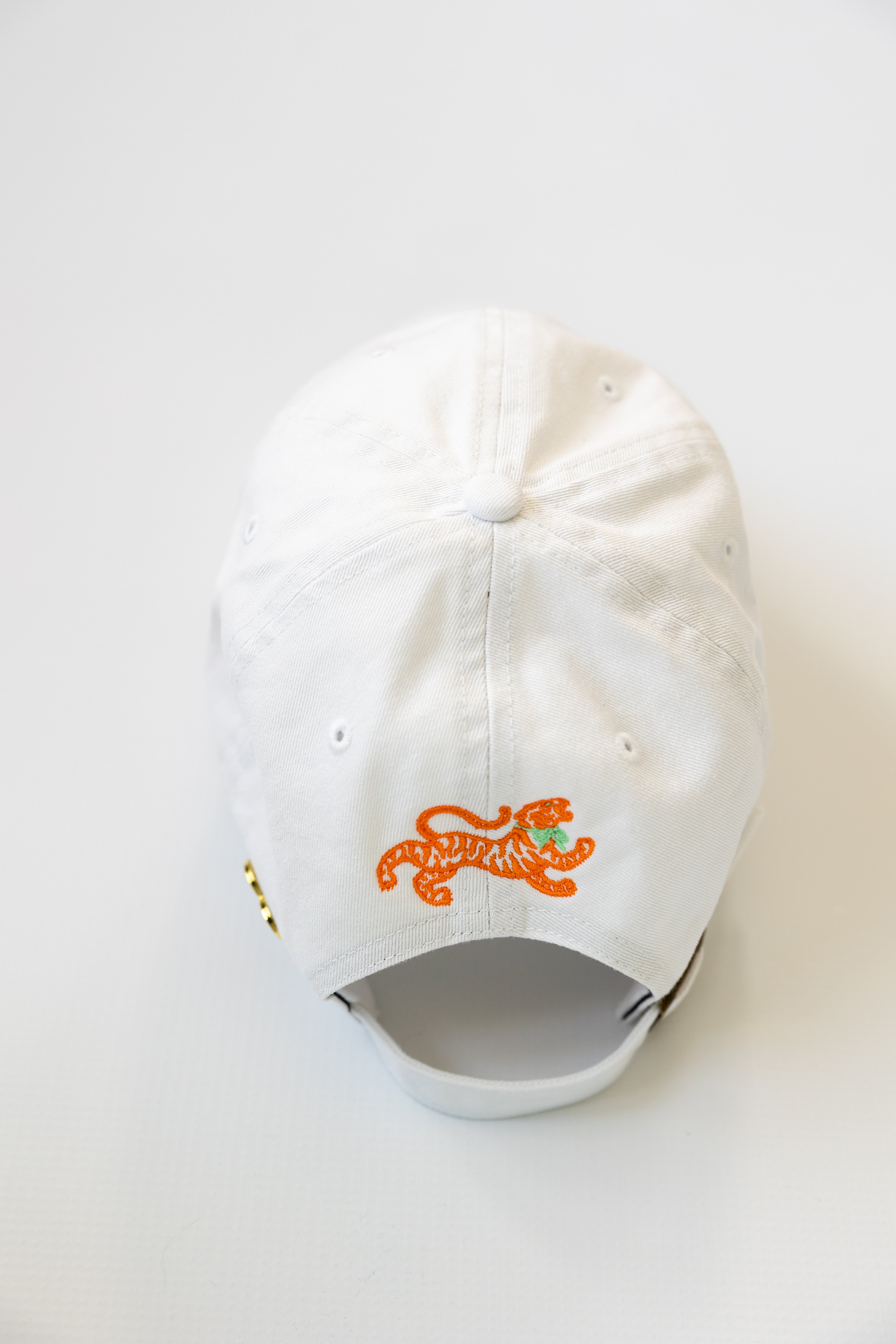 White cap with orange tiger logo on a white background