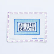 Needlepoint pattern with 'At the Beach' text in navy blue on a white background