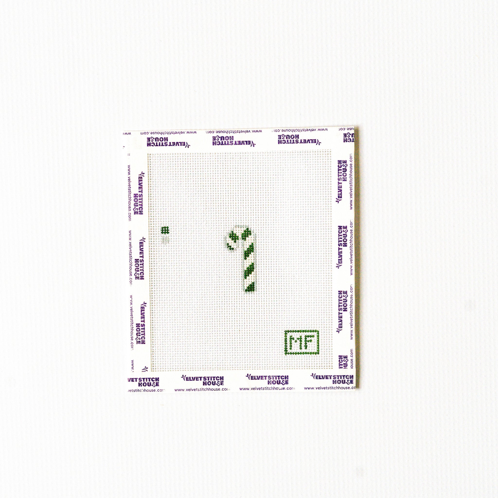 Needlepoint pattern with a green and white striped mini candy cane.