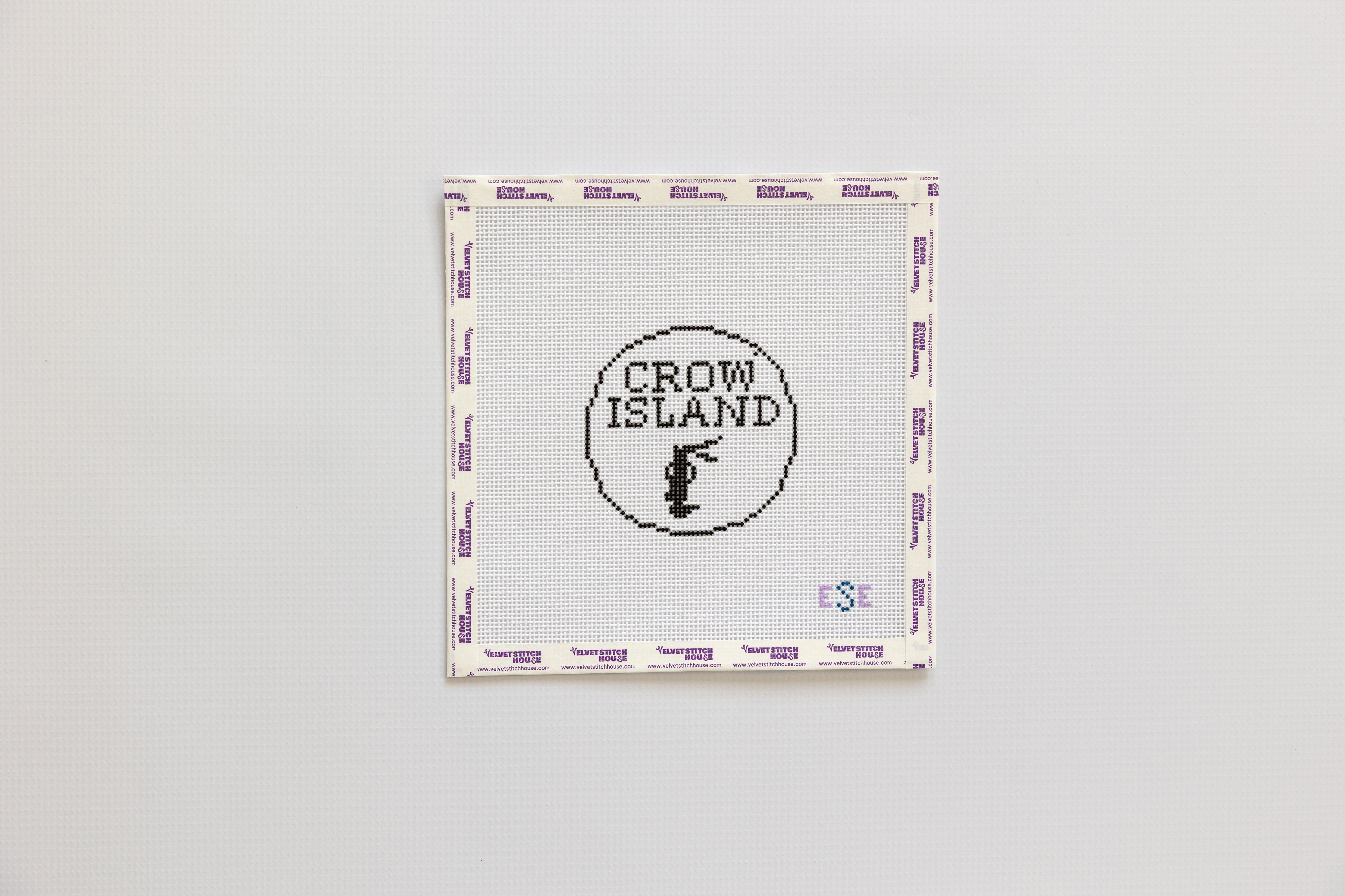 Needlepoint pattern with 'Crow Island' logo on a gray background