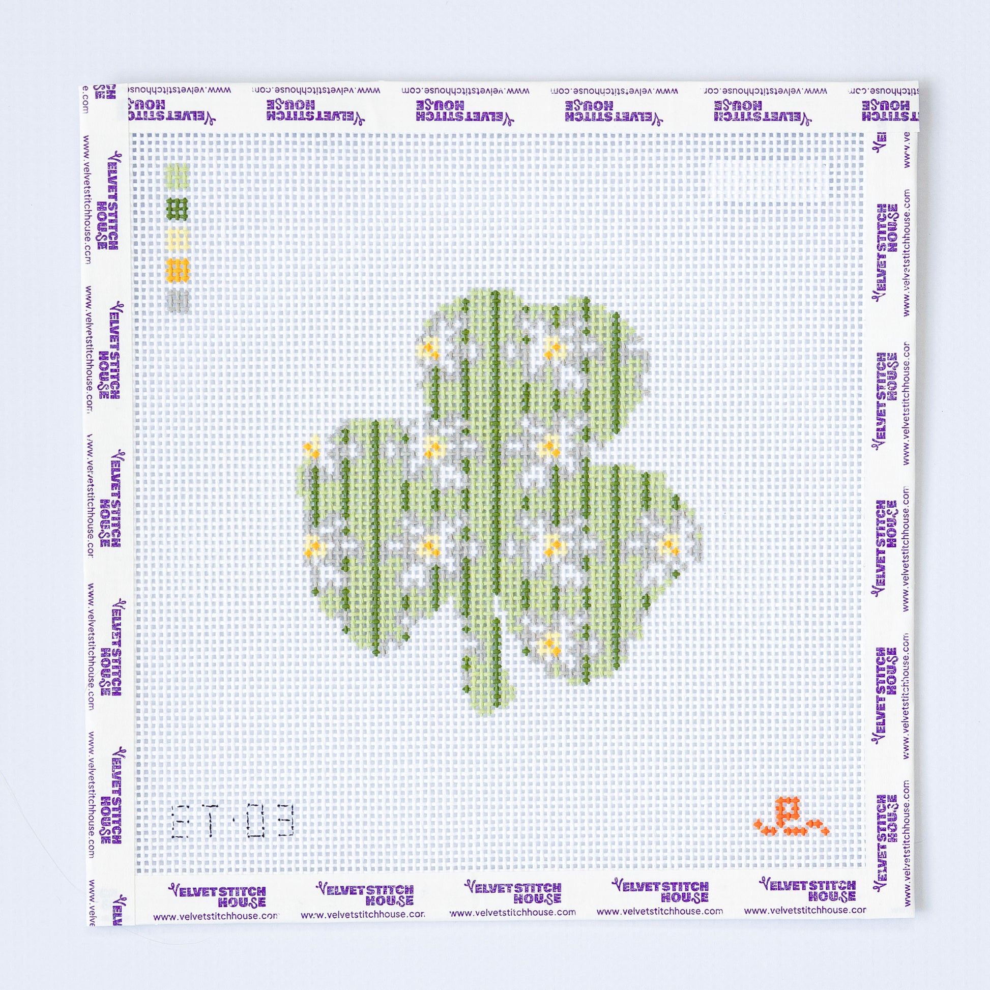 Needlepoint pattern for a shamrock with flowers on a white background