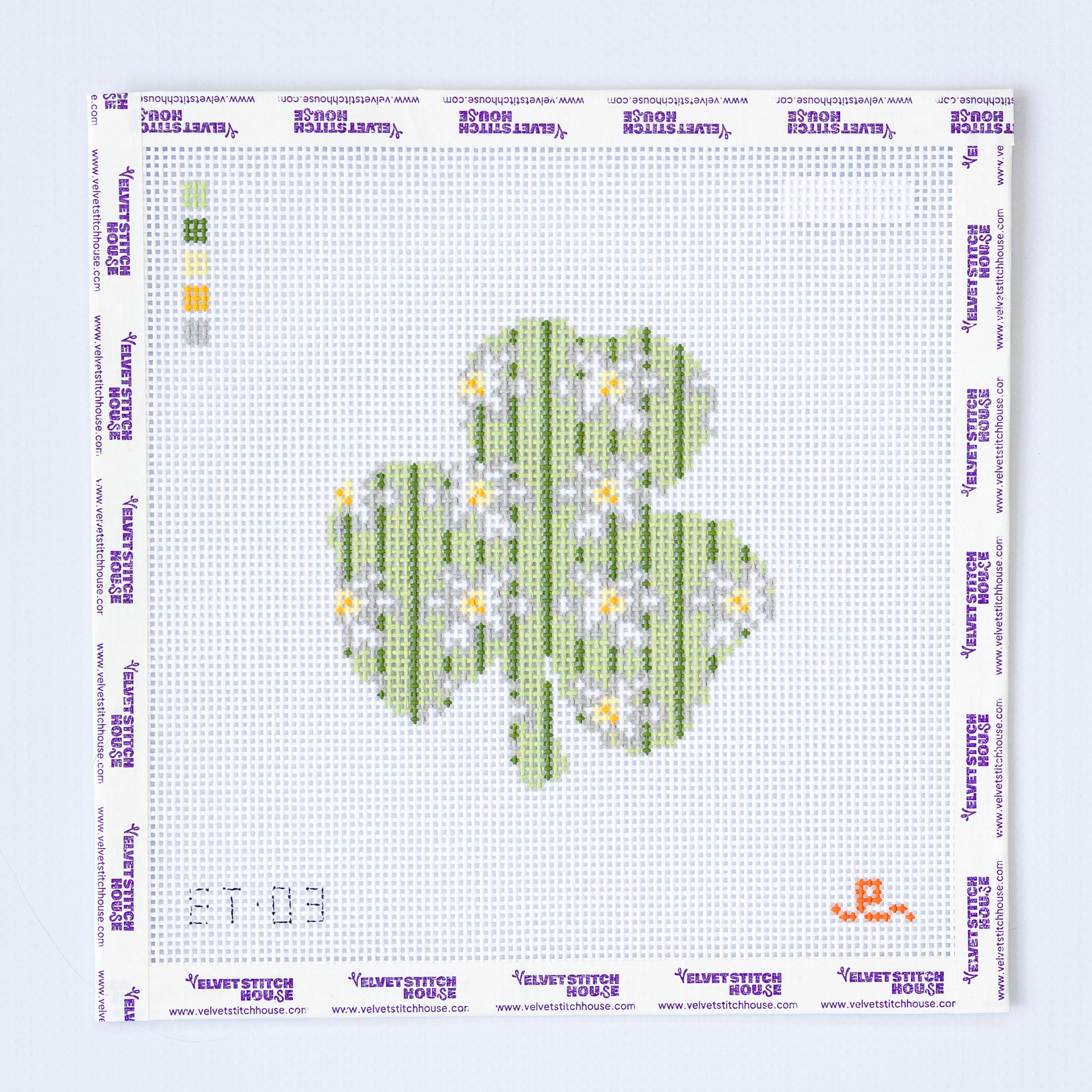 Needlepoint pattern for a shamrock with flowers on a white background