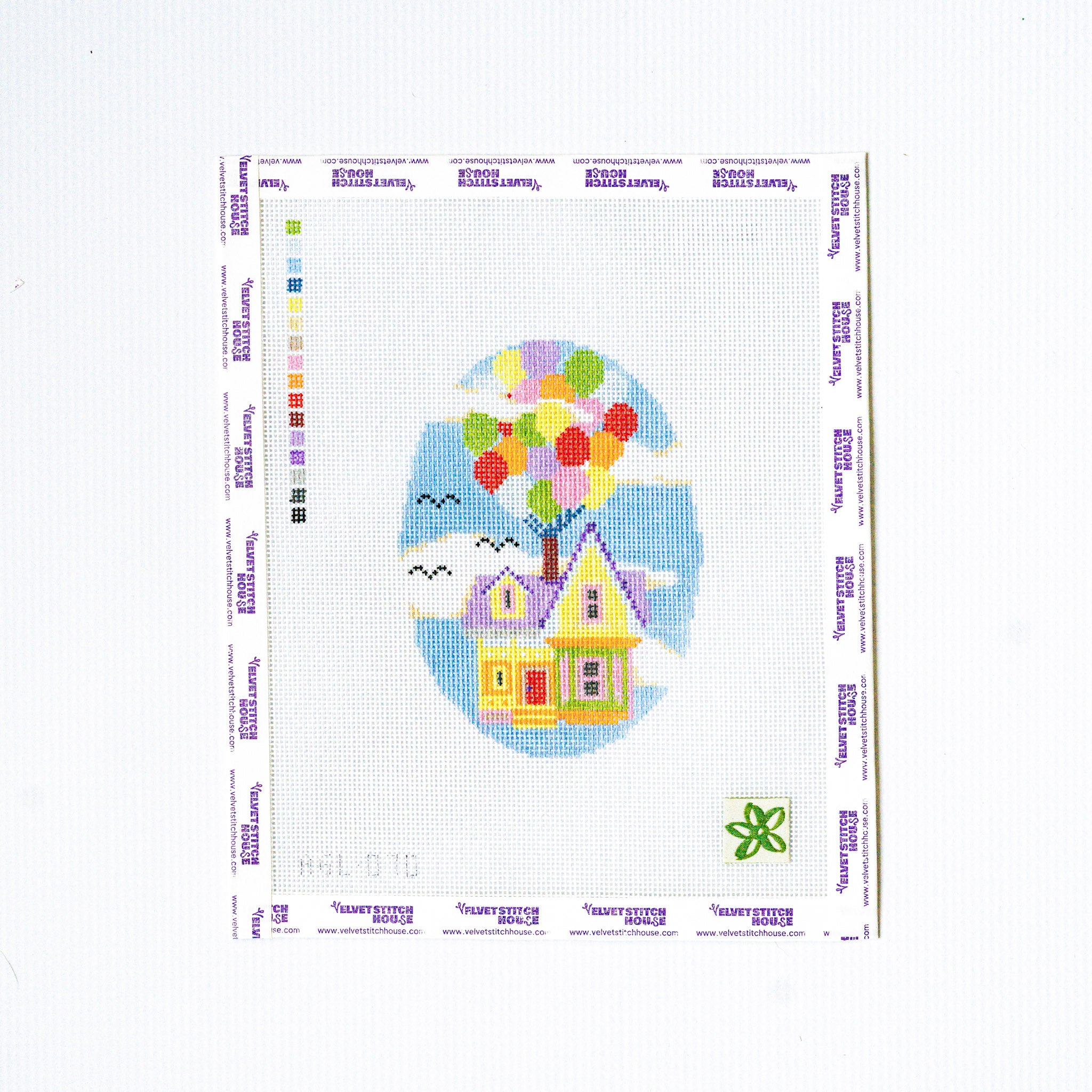 Cross-stitched design of a house with balloons on a white background
