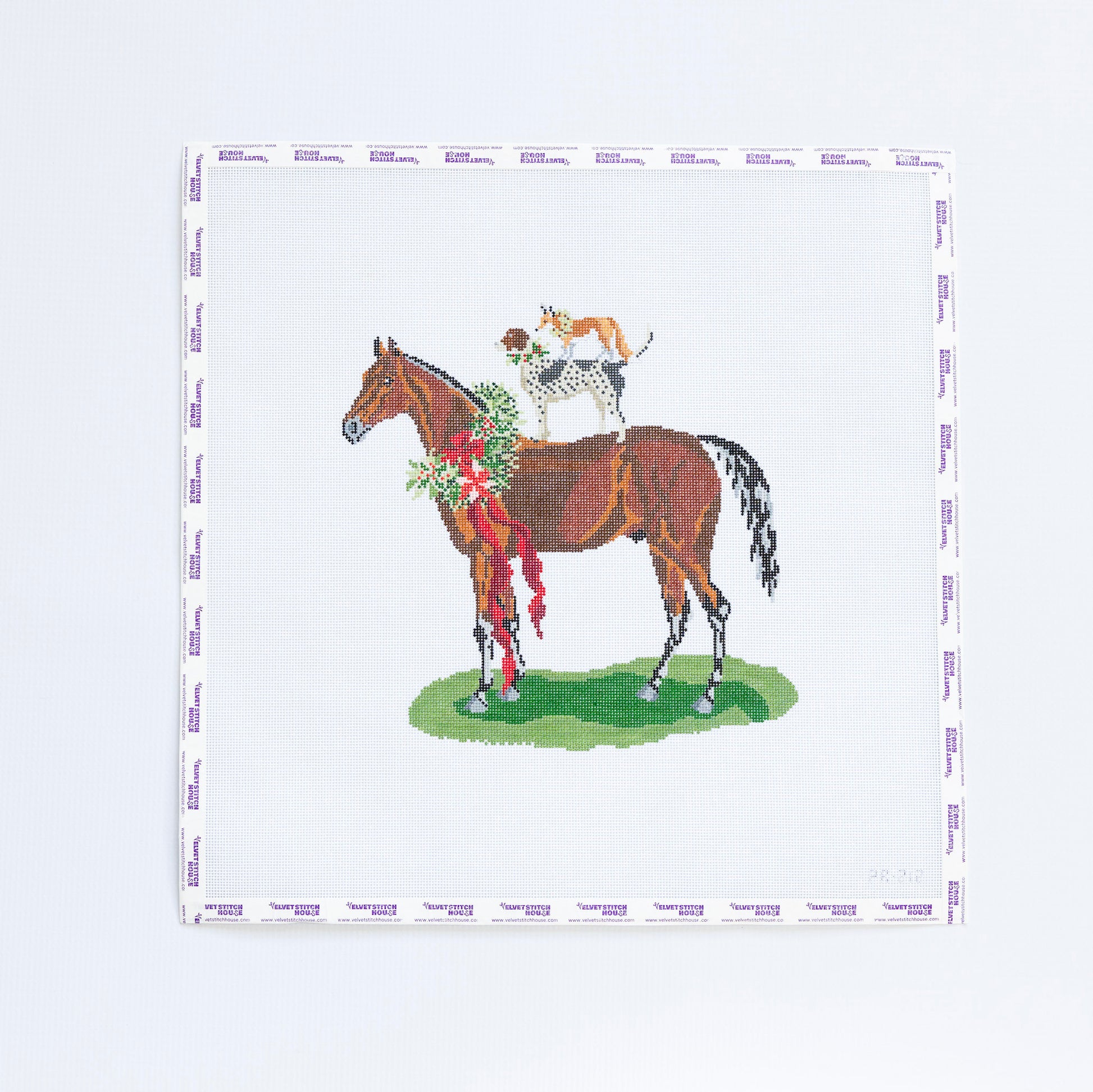 Needlepoint pattern with a horse and jockey design with dog and a fox on a white background