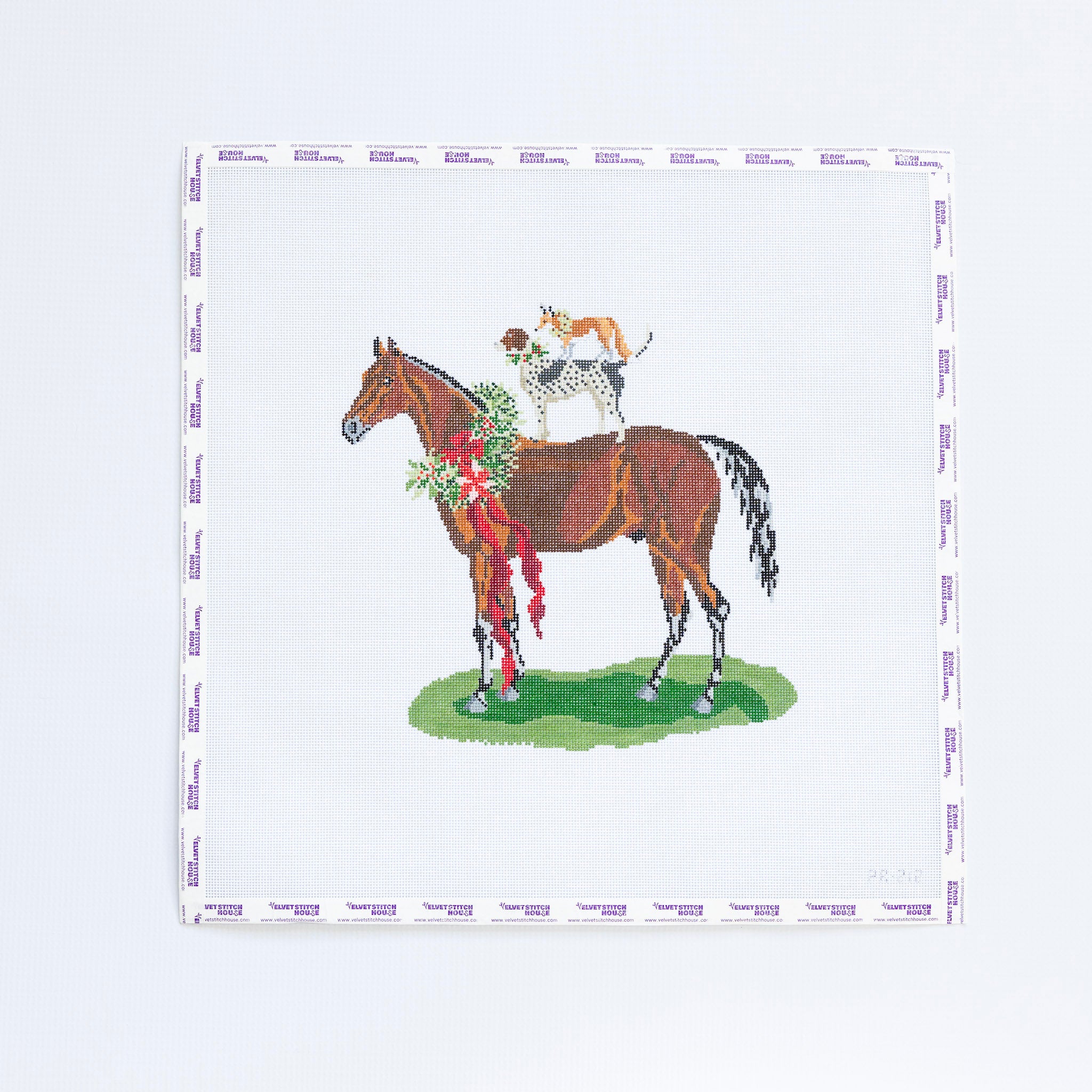 Needlepoint pattern with a horse and jockey design with dog and a fox on a white background