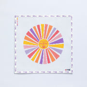 Needlepoint pattern of a large sun with a yellow fave and multicolored rays 