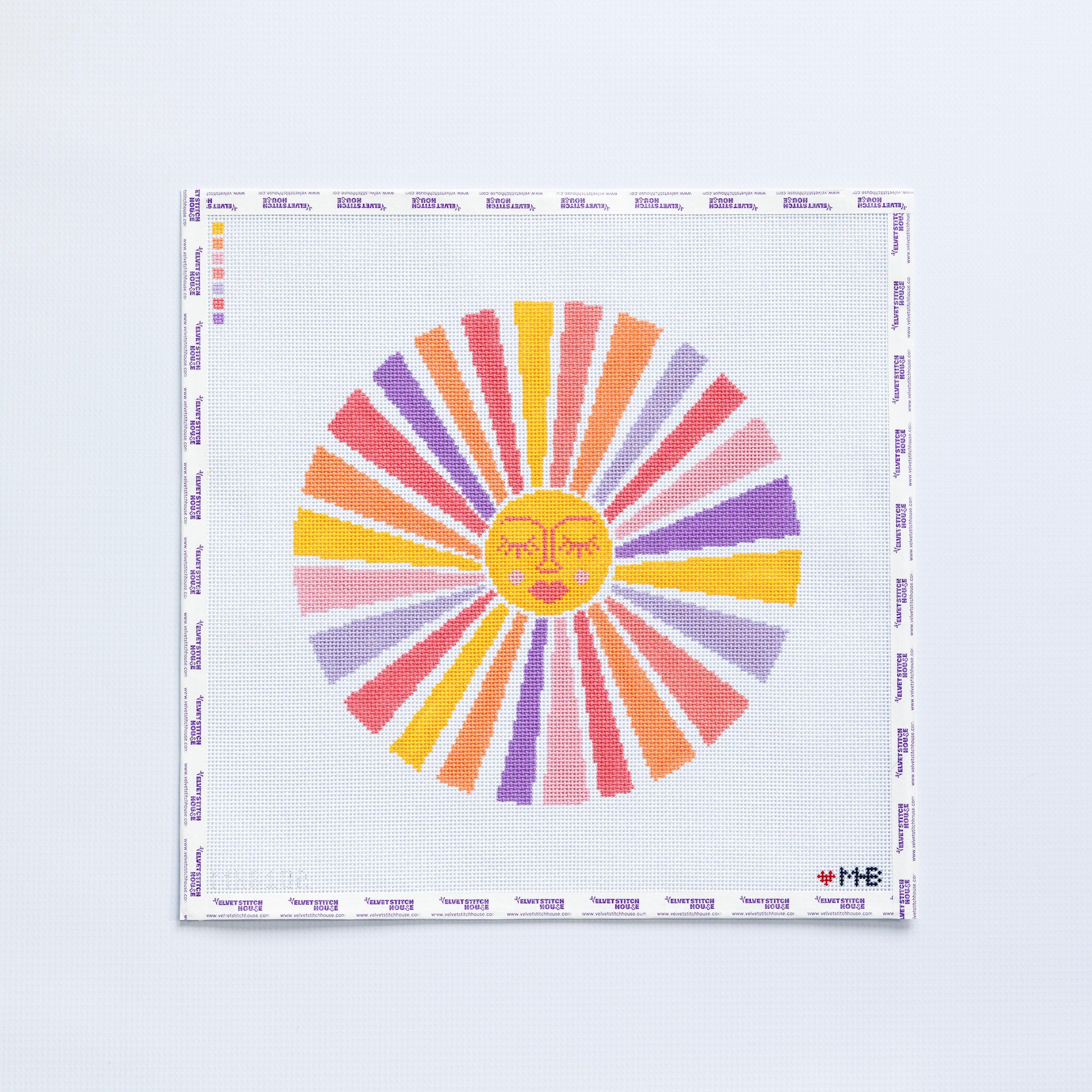 Needlepoint pattern of a large sun with a yellow fave and multicolored rays 