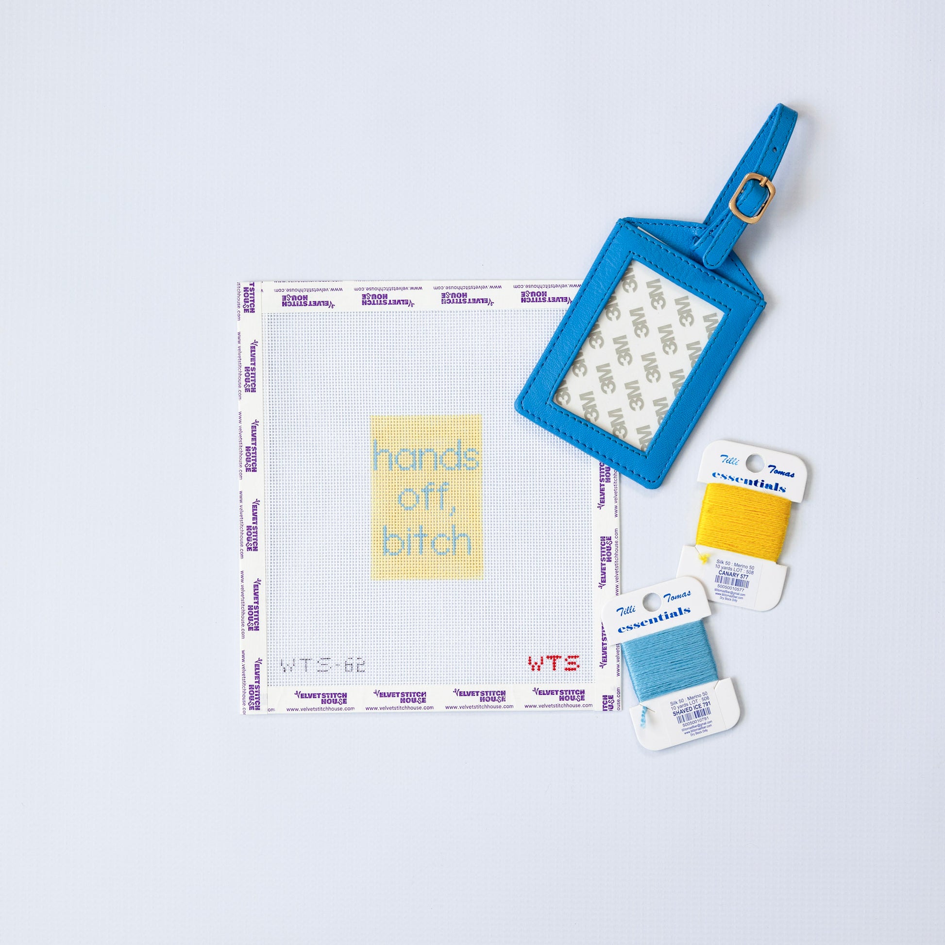 Needlepoint luggage tag pattern with "hand off, bitch" in light blue on a light yellow background 