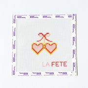 Needlepoint pattern with pink and red heart locket on a white background