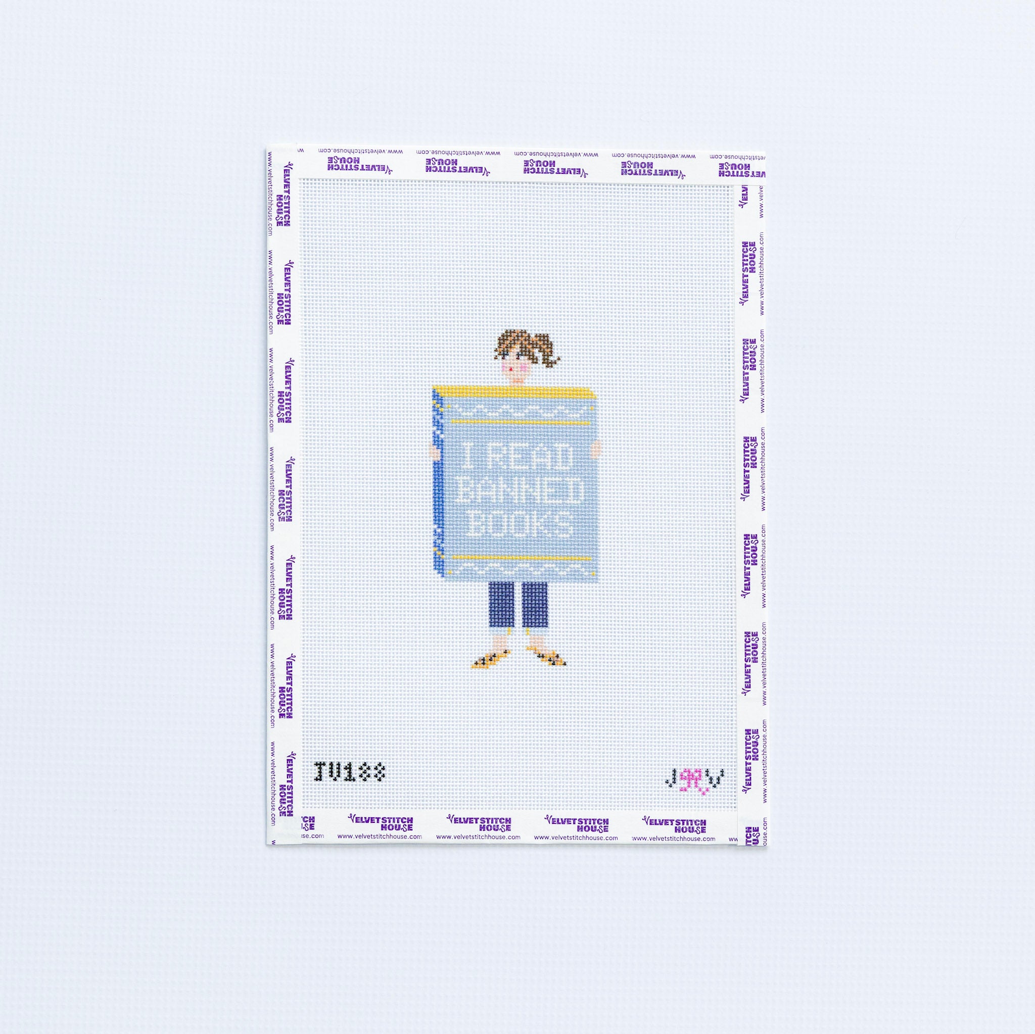 Needlepoint design of a person holding a book titled 'I Read Banned Books' on a white background