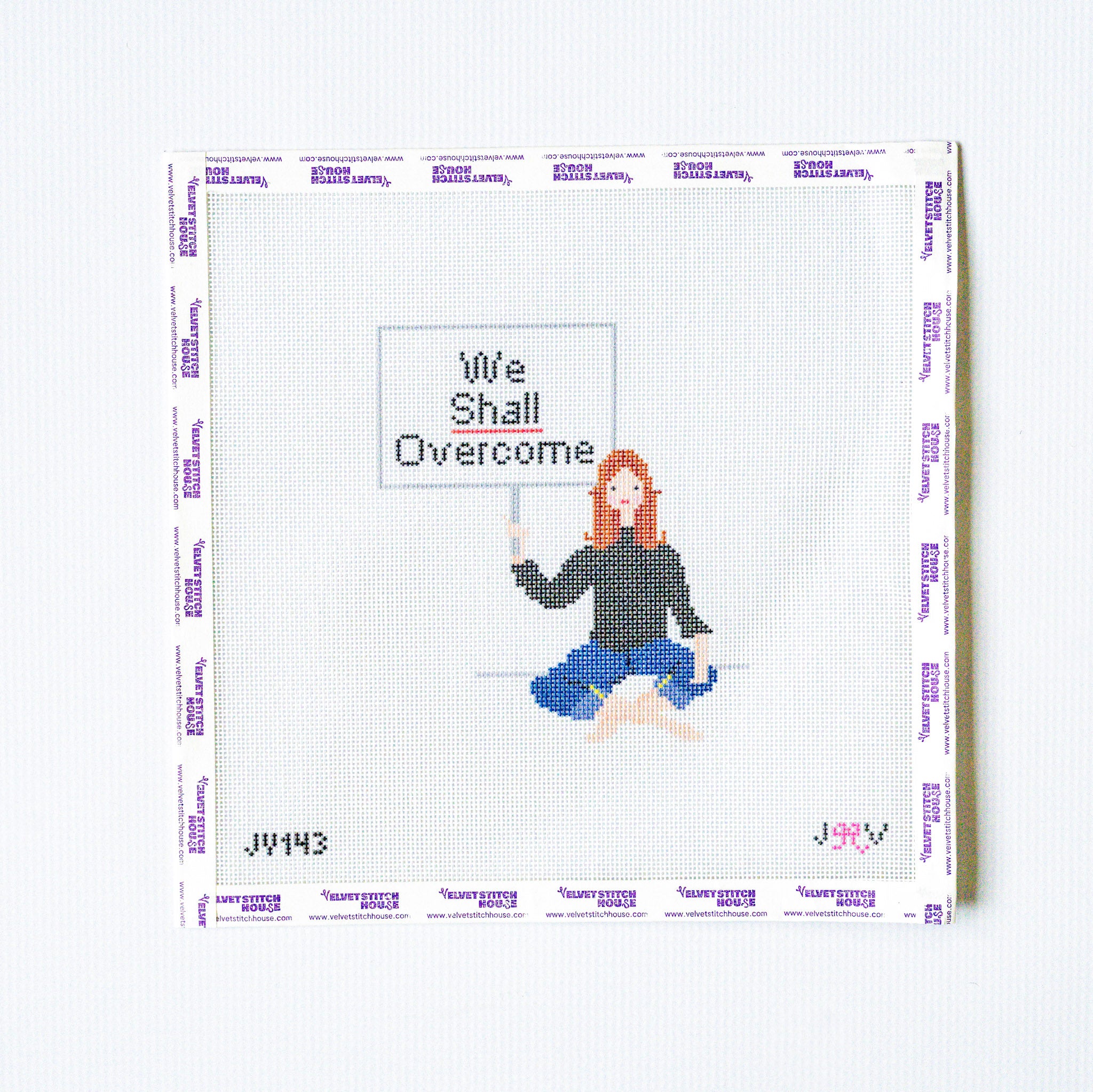 Needlepoint design of a person holding a 'We Shall Overcome' sign on a white background.