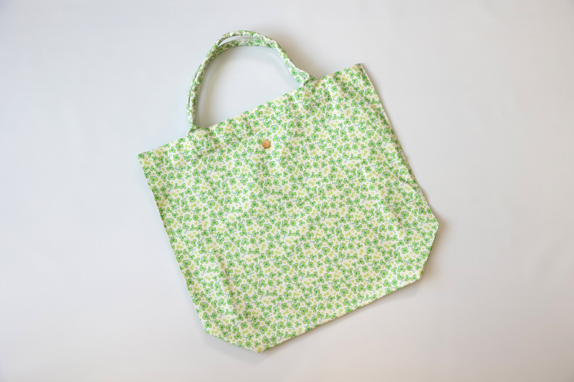 Green floral-patterned tote bag on a light gray background