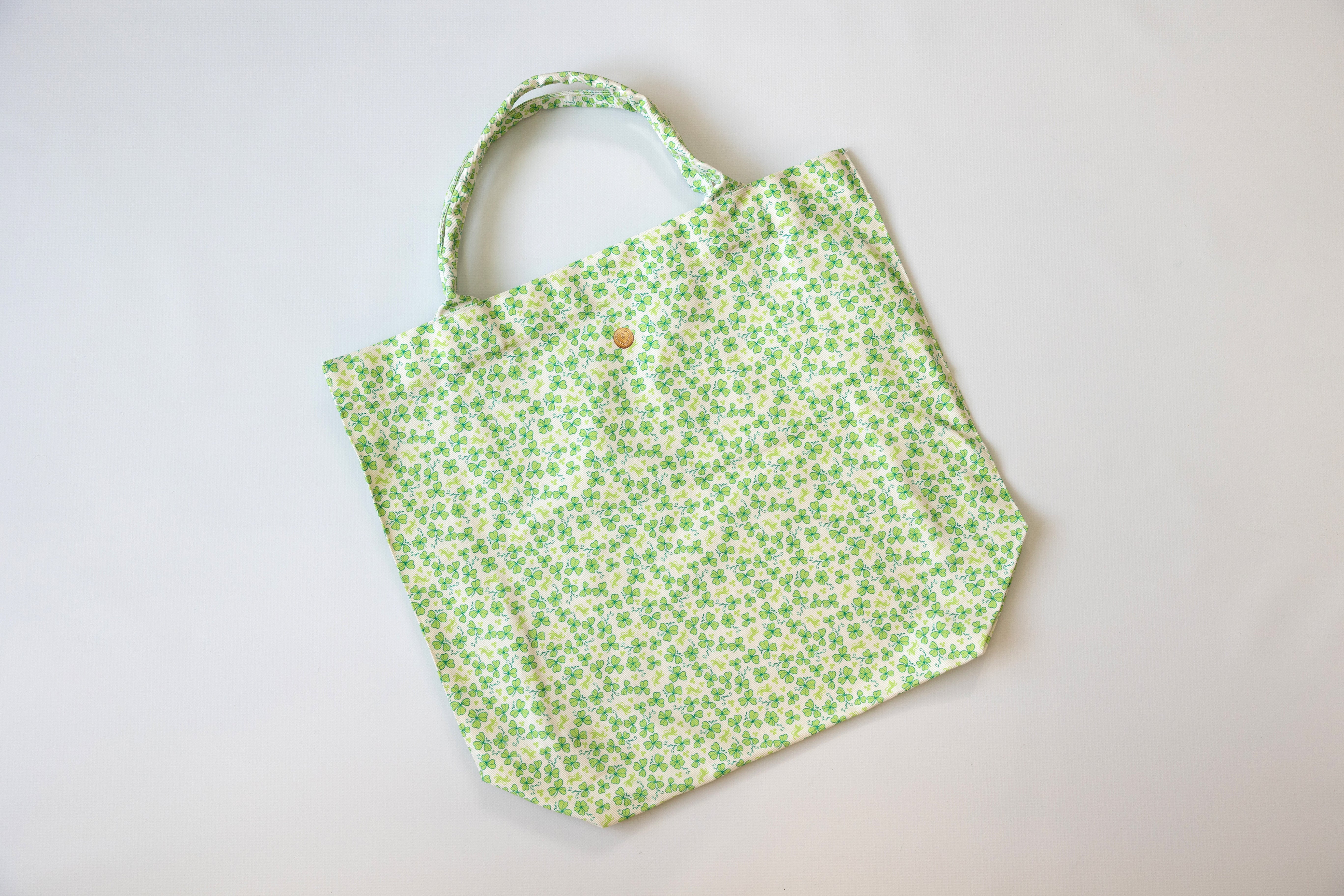 Green floral-patterned tote bag on a light gray background