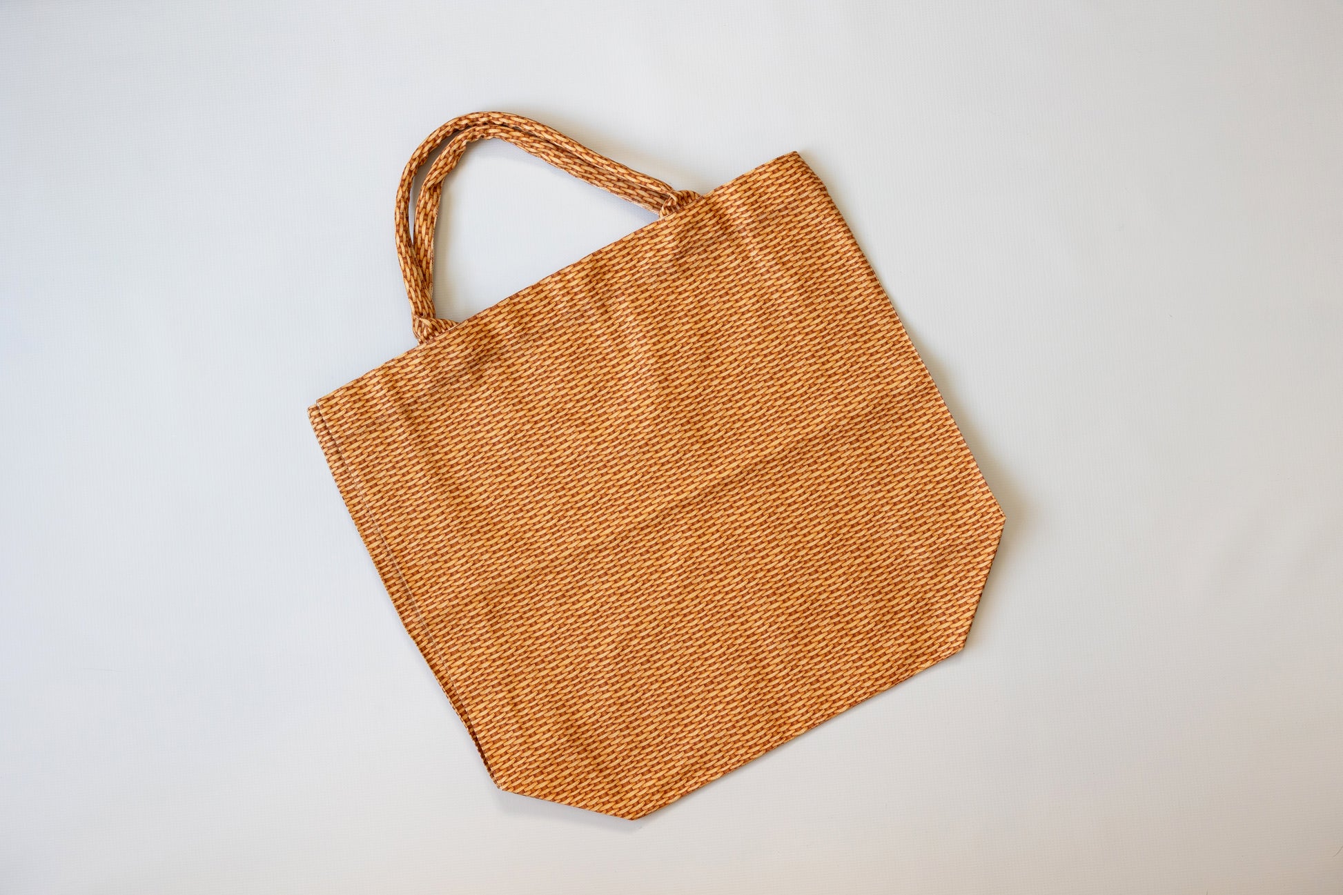 Brown woven tote bag on a light gray background