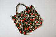 Fabric tote bag with strawberry pattern on a light gray background