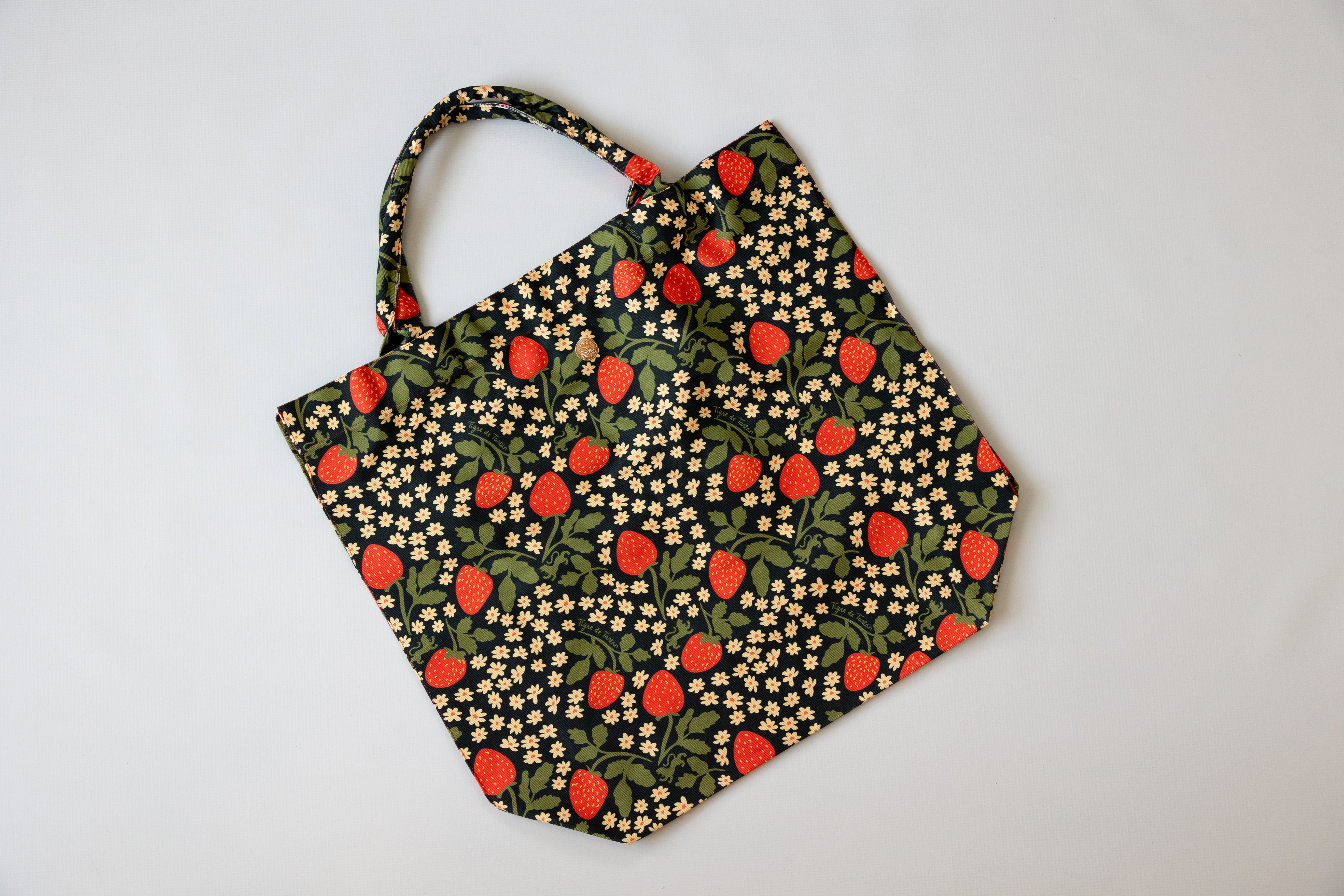 Fabric tote bag with strawberry pattern on a light gray background