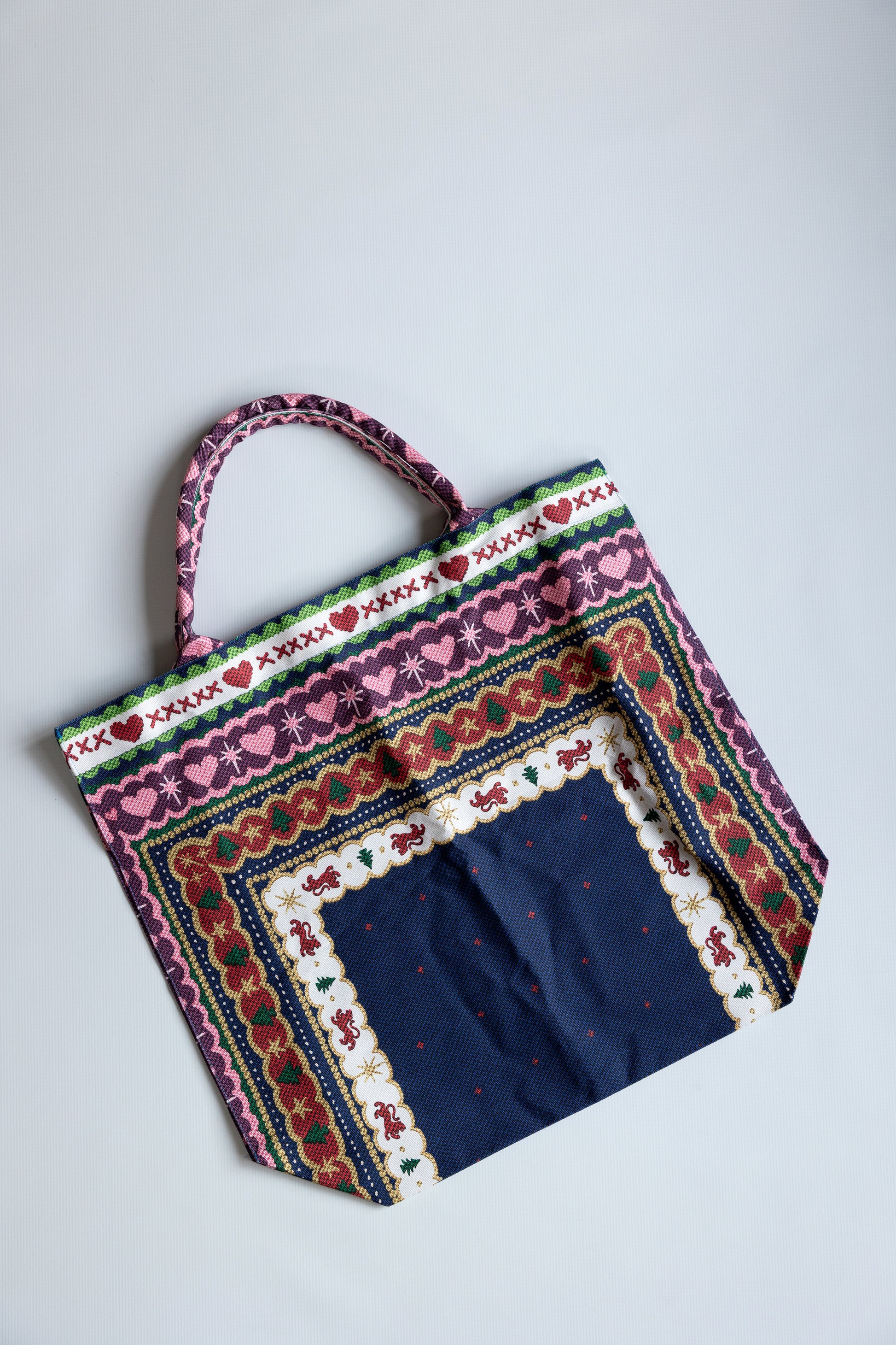 Colorful fabric bag with intricate patterns on a light gray background