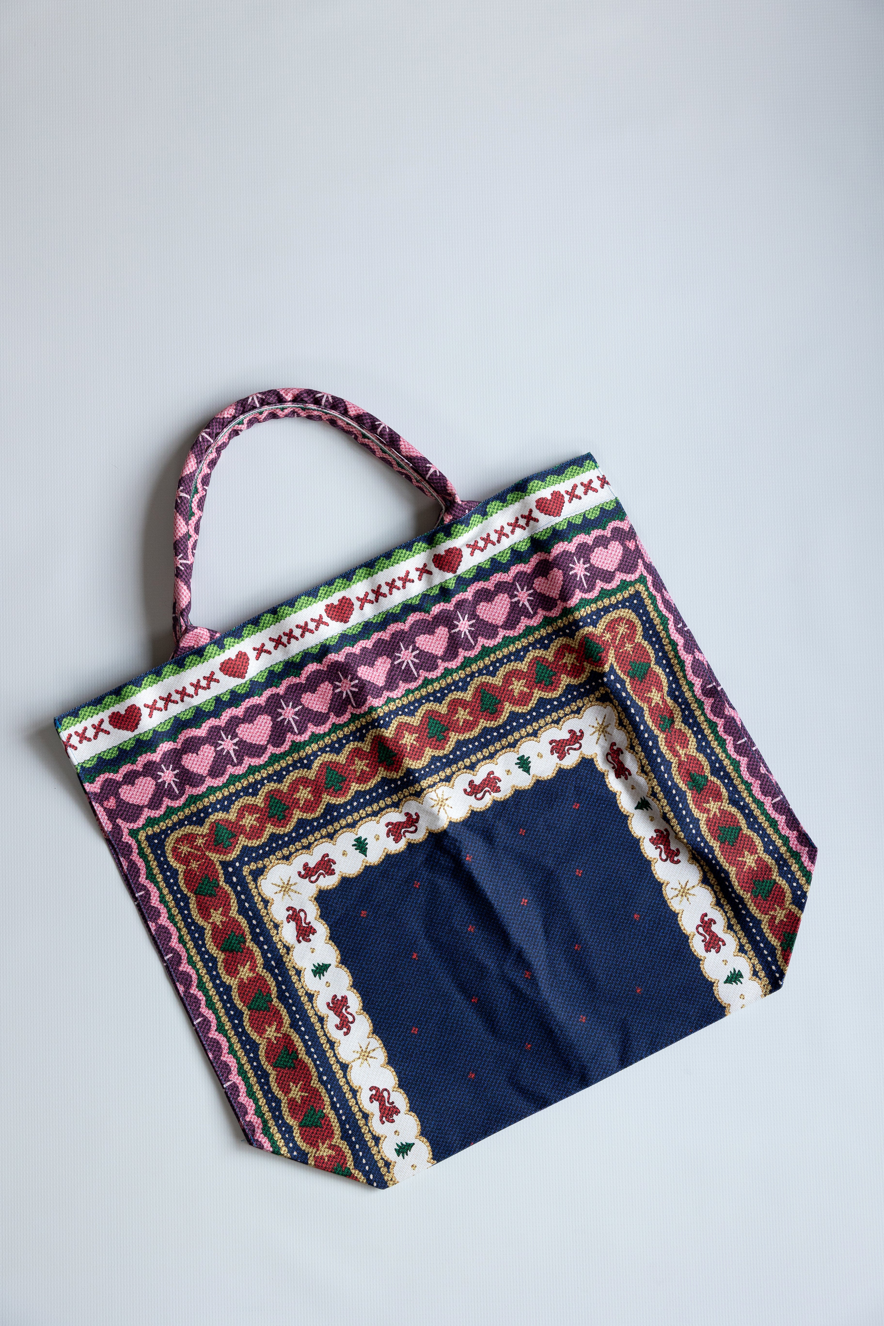 Colorful fabric bag with intricate patterns on a light gray background