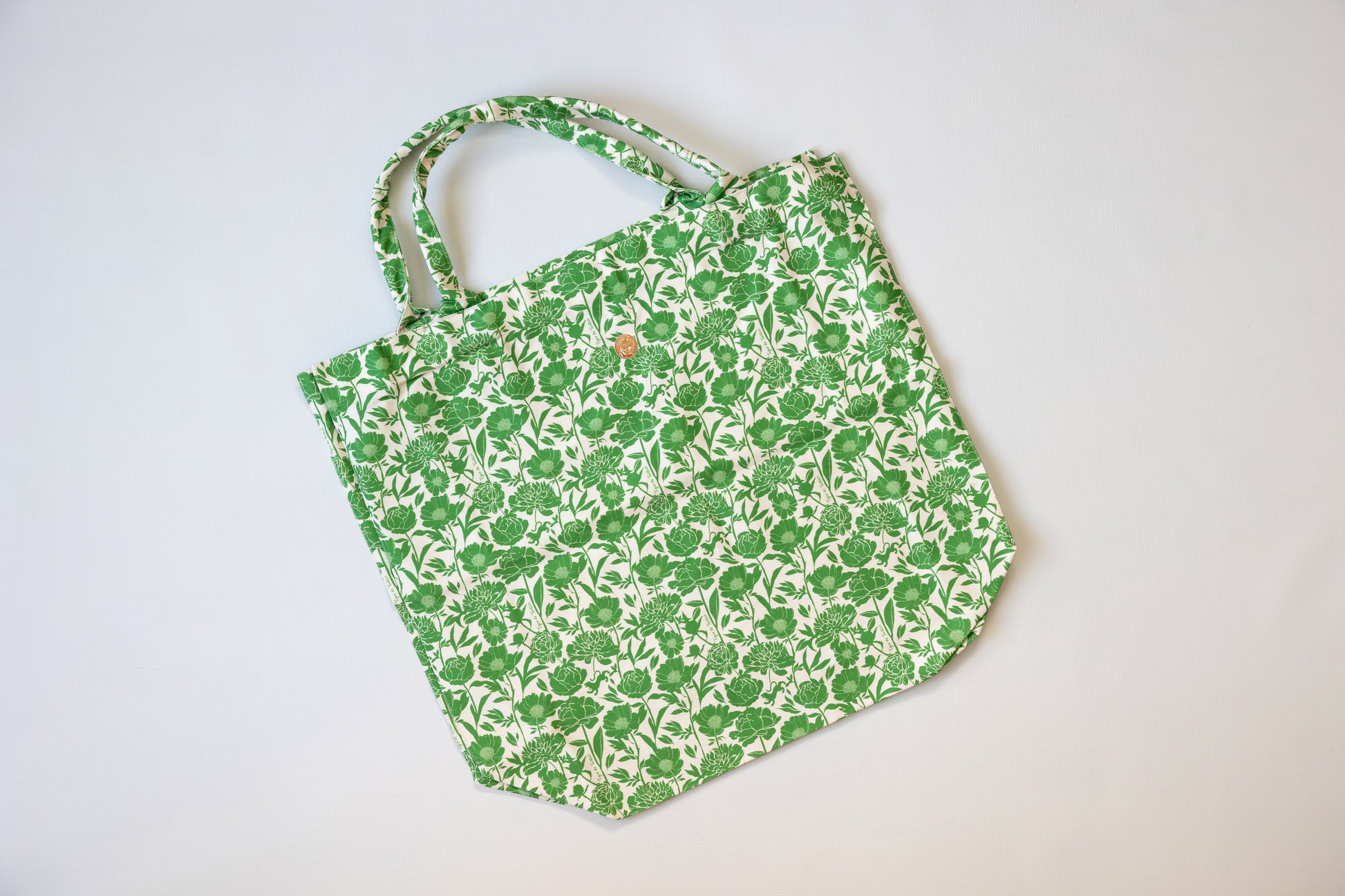 Green floral-patterned tote bag on a white background