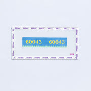 Needlepoint pattern key fob with 60043 zip code in yellow on a blue background with green scallop edge. 