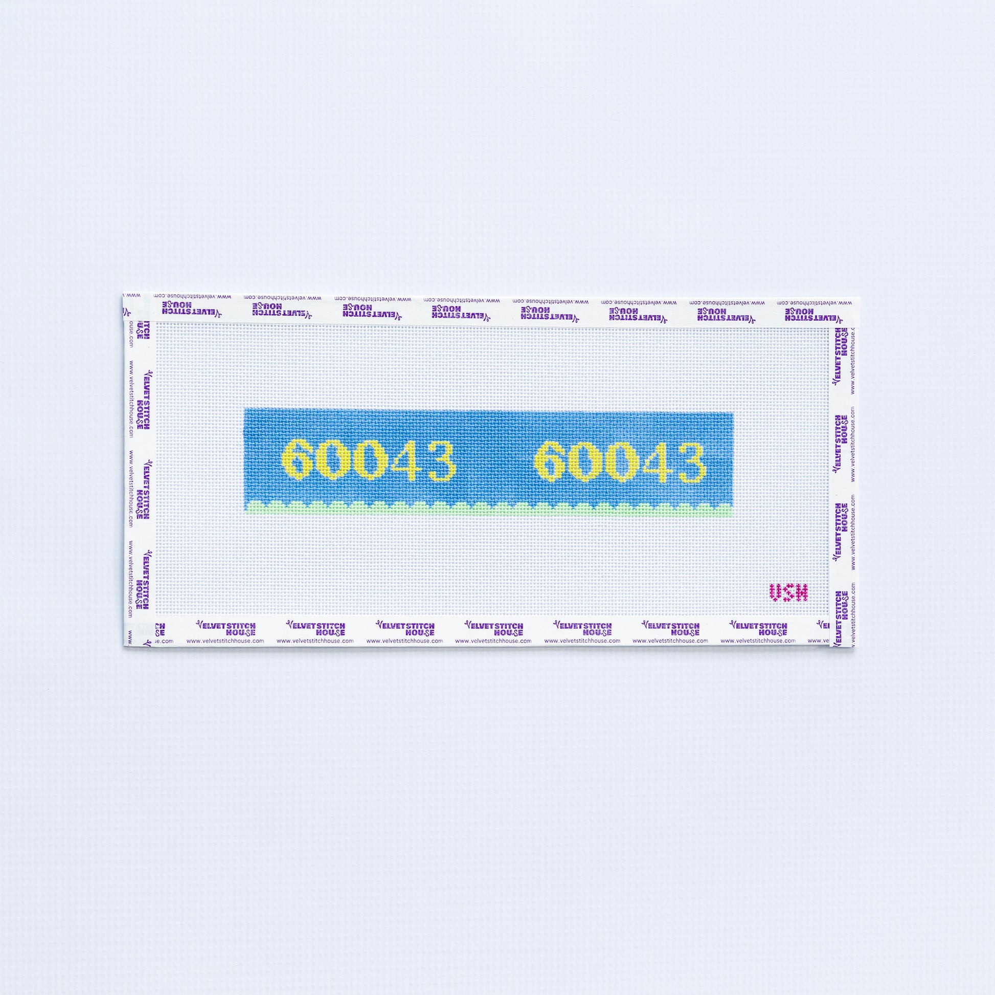 Needlepoint pattern key fob with 60043 zip code in yellow on a blue background with green scallop edge. 