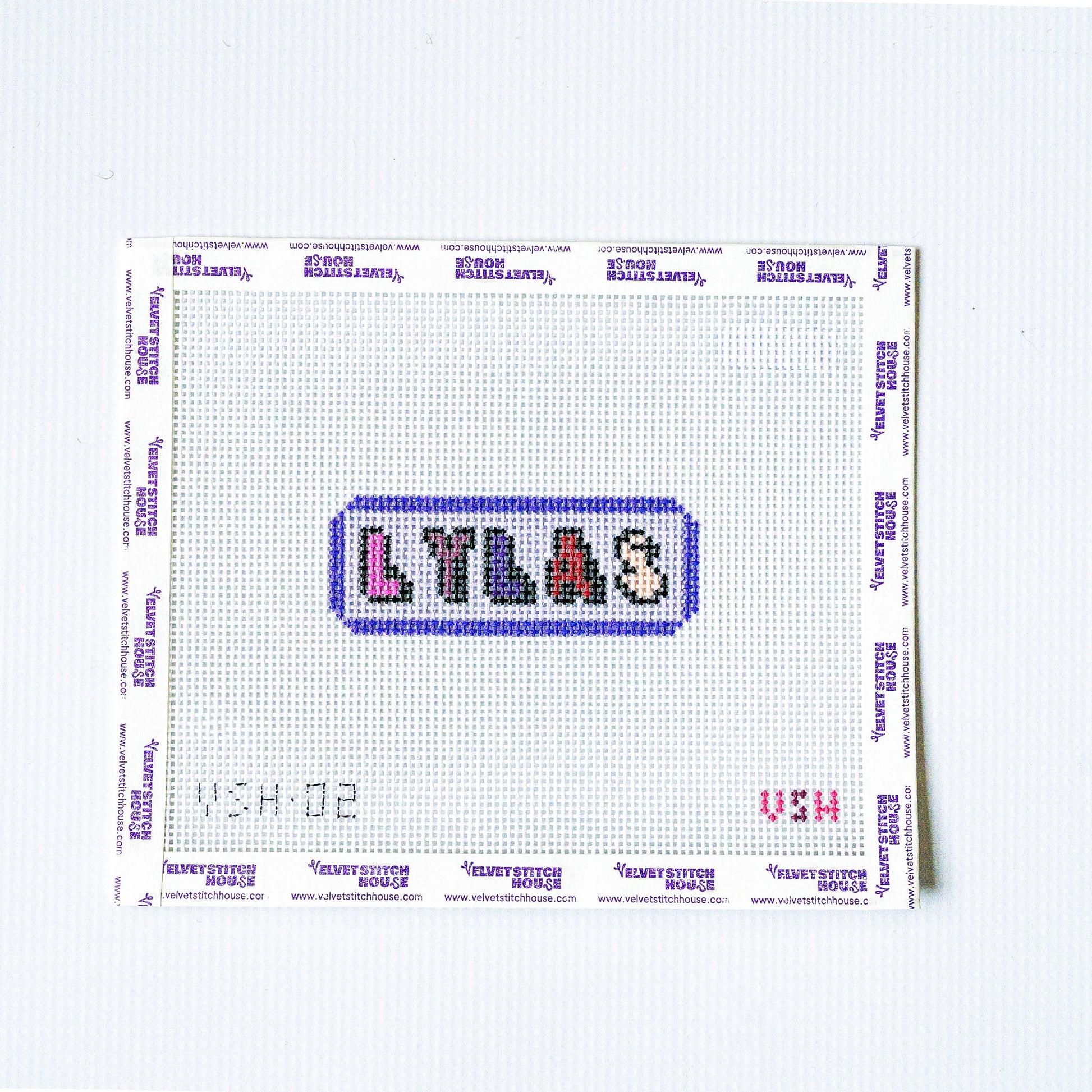 Needlepoint pattern with 'LYLAS' text on a white fabric background love you like a sister

