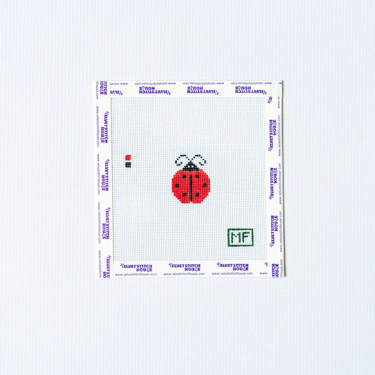 Needlepoint design of mini red ladybug on white canvas