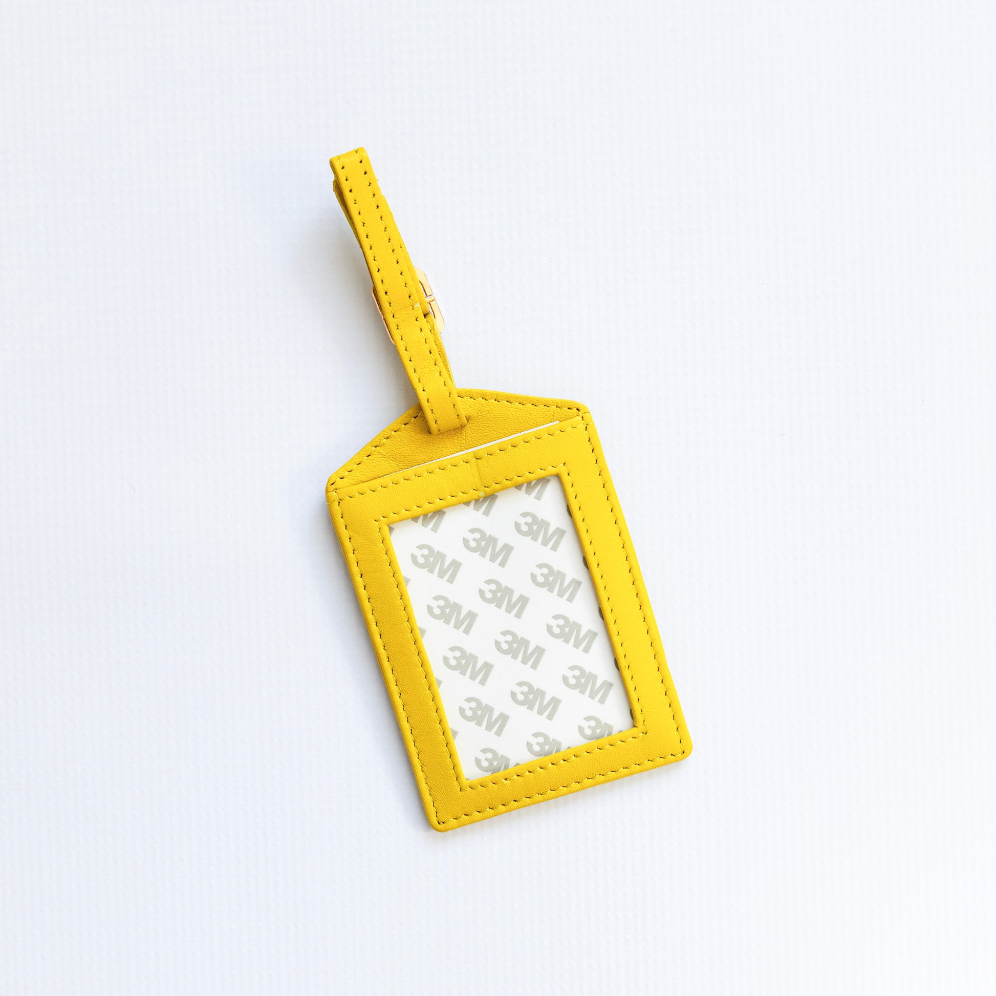 Yellow luggage tag with a clear window on a white background