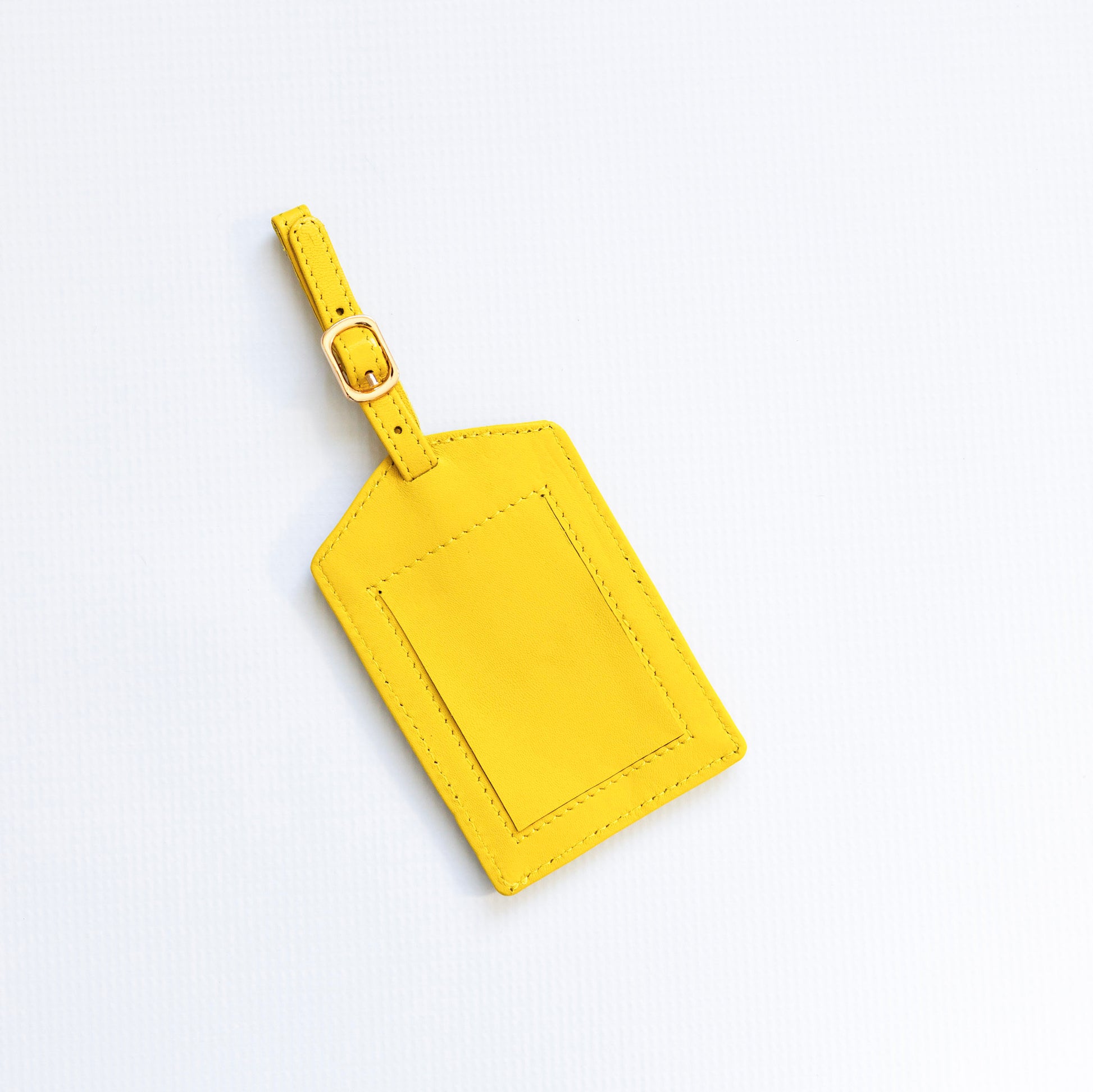 Yellow luggage tag on a light gray background