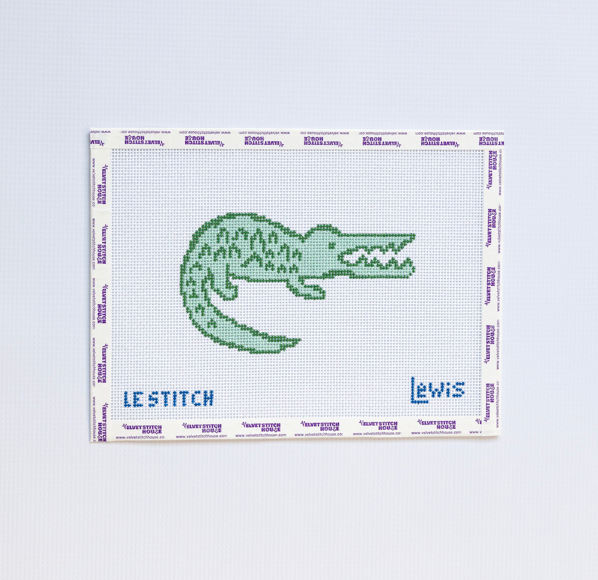 Needlepoint pattern of a green alligator design on a white background