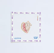 Needlepoint pattern with a shell design on a white fabric background