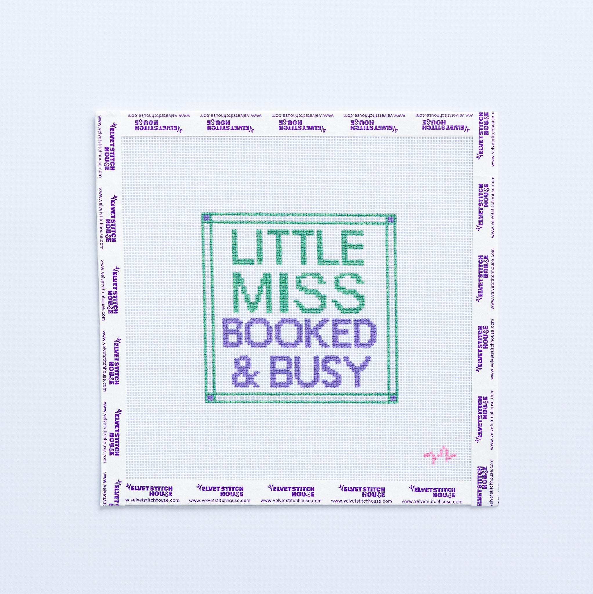 Needlepoint pattern with 'Little Miss Booked & Busy' green and purple text on a white background