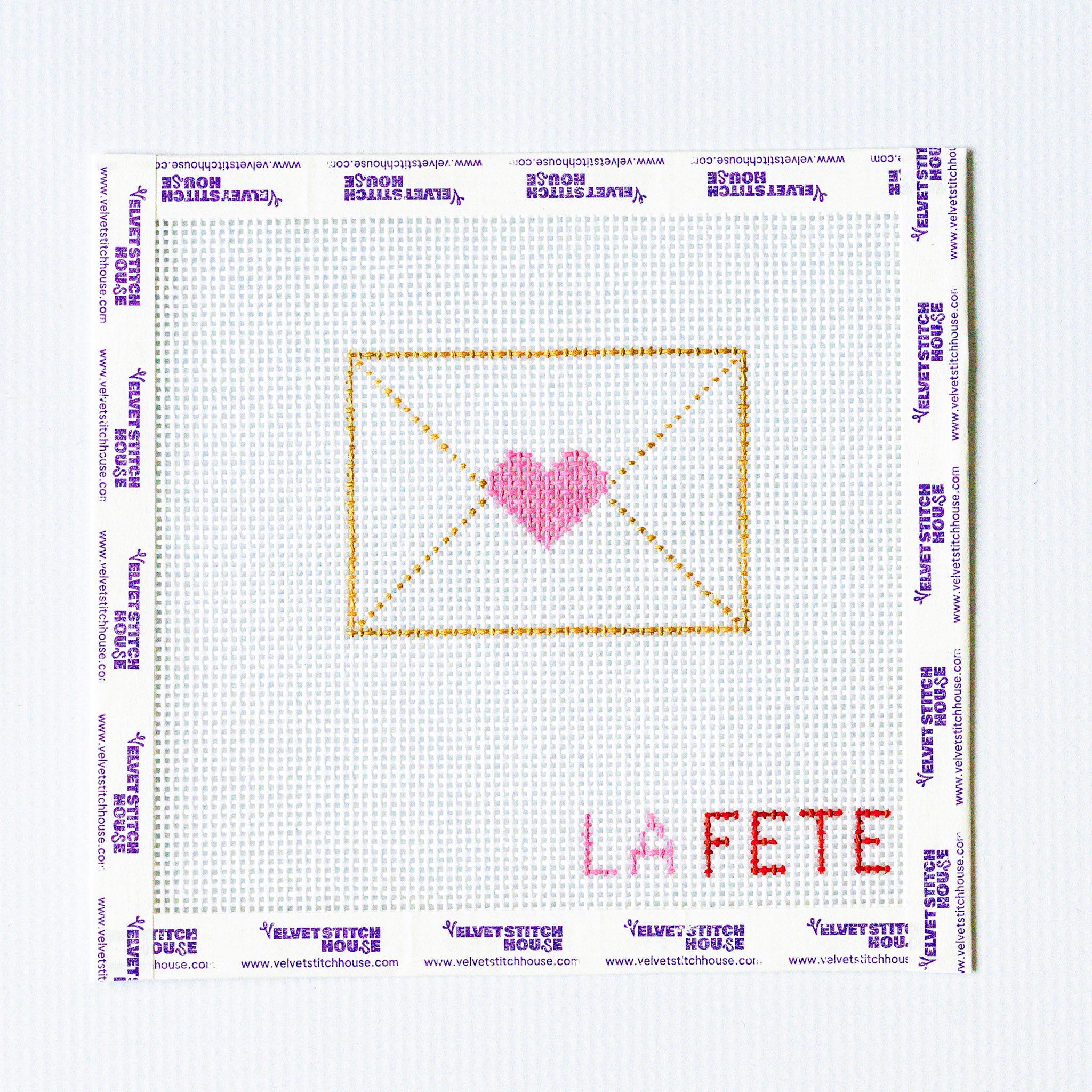 Needlepoint design of an envelope with a heart and 'LA FETE' text on a grid background.