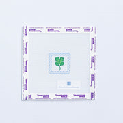 Needlepoint pattern with a green four-leaf clover on a white background