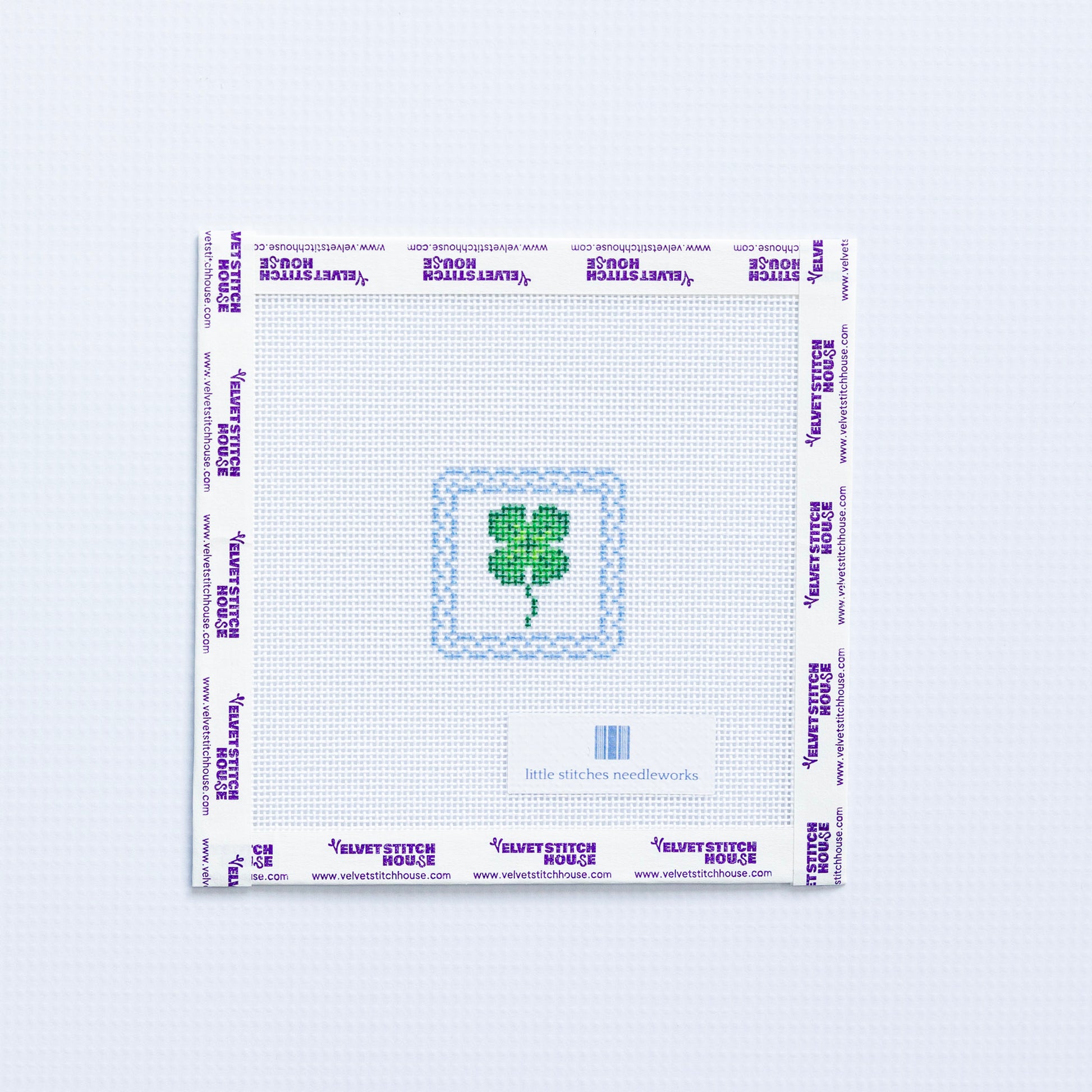 Needlepoint pattern with a green four-leaf clover on a white background