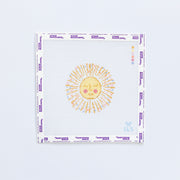 Needlepoint pattern of a yellow and gold sun with a face on a white background
