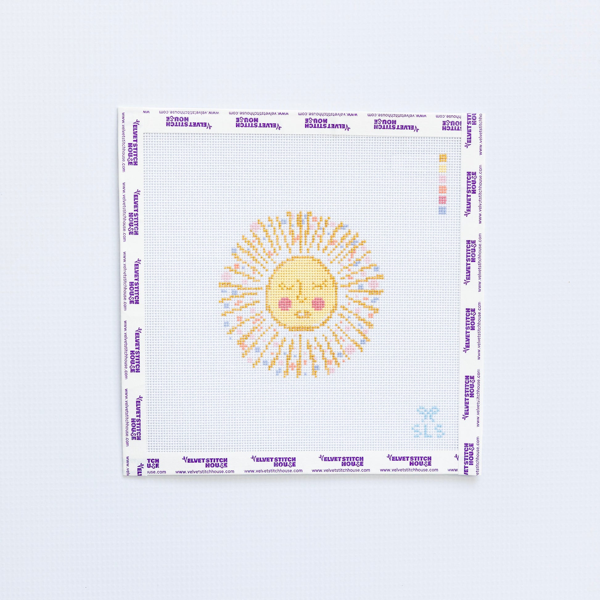 Needlepoint pattern of a yellow and gold sun with a face on a white background