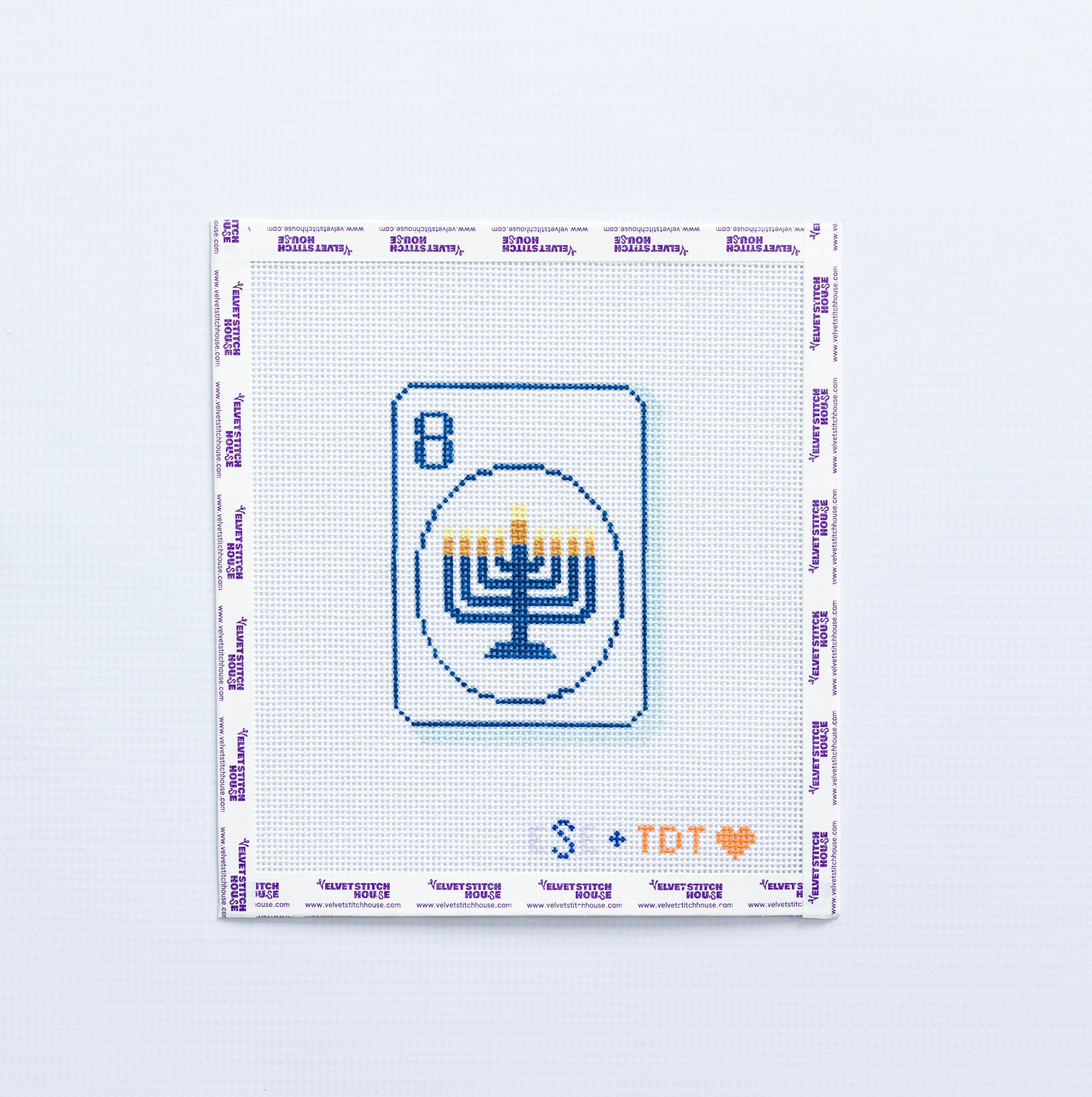 Needlepoint pattern with a menorah design in blue on a mahjong tile on a white background