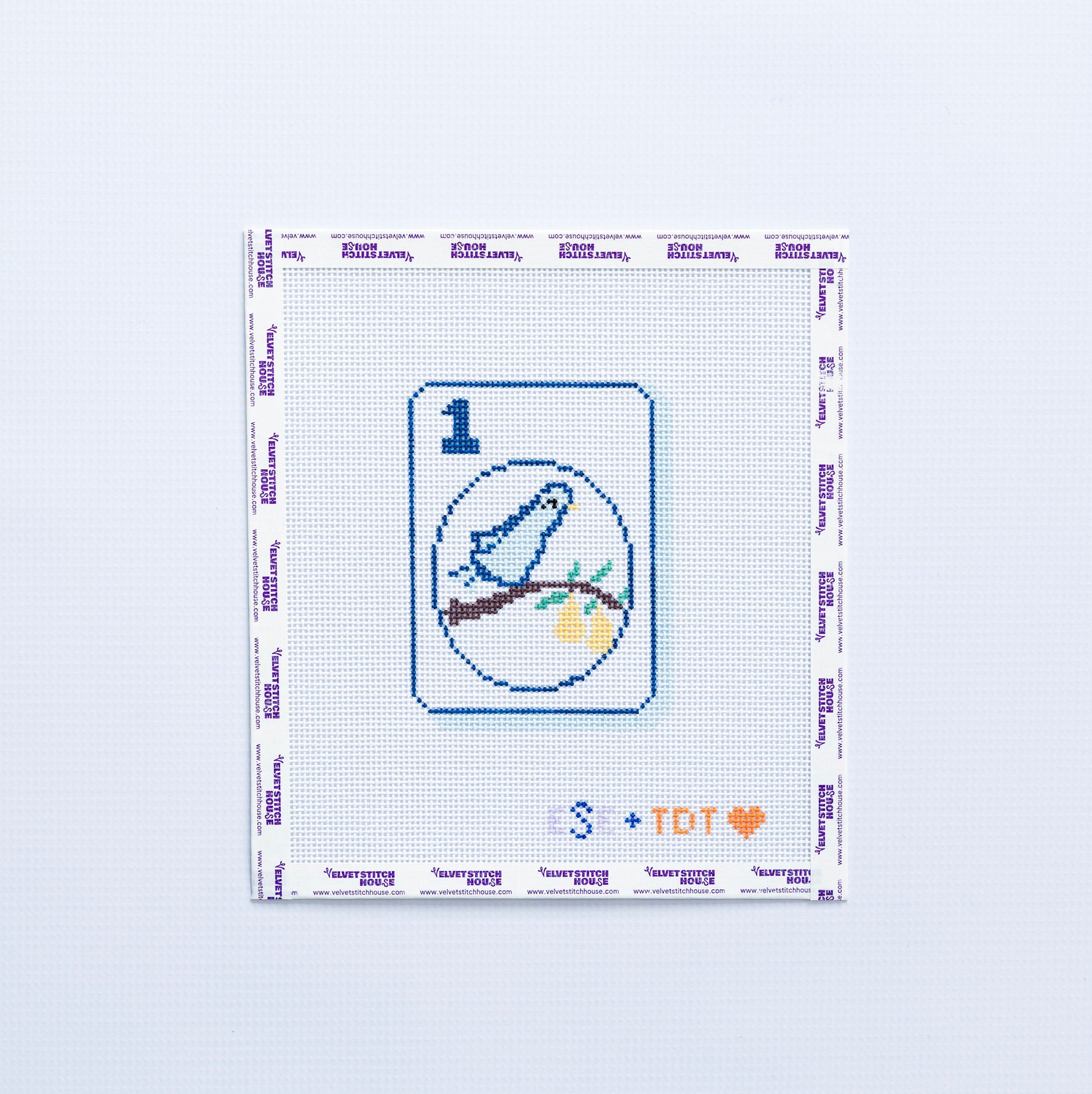 Needlepoint design with a blue partridge bird and branch pattern on a 1 mahjong tile on a white background. 