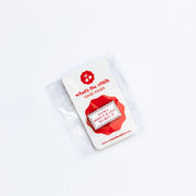 Red and white needleminder in packaging with 'what the stitch' branding on a white background