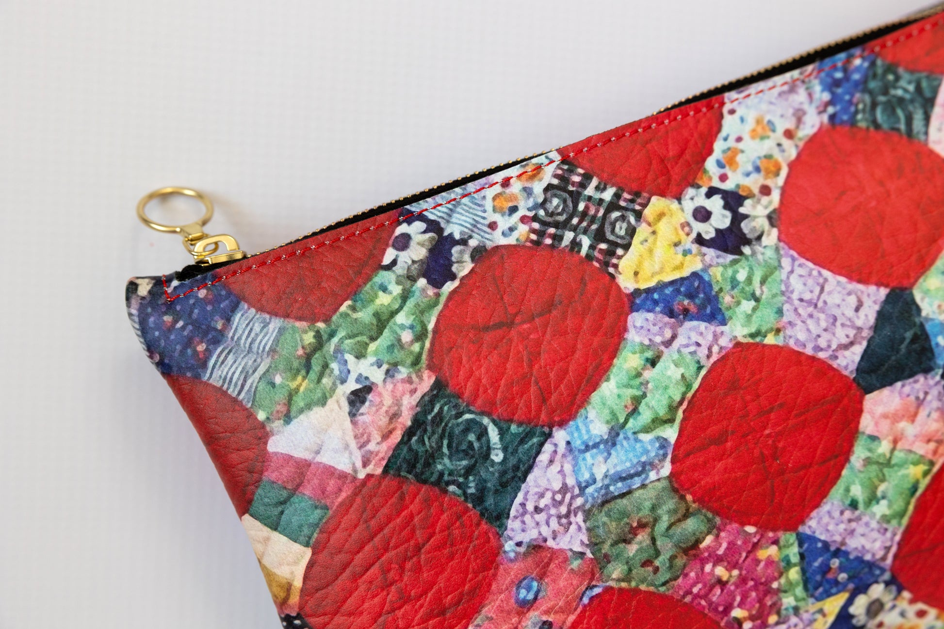 Colorful patchwork pouch with a gold zipper on a white background