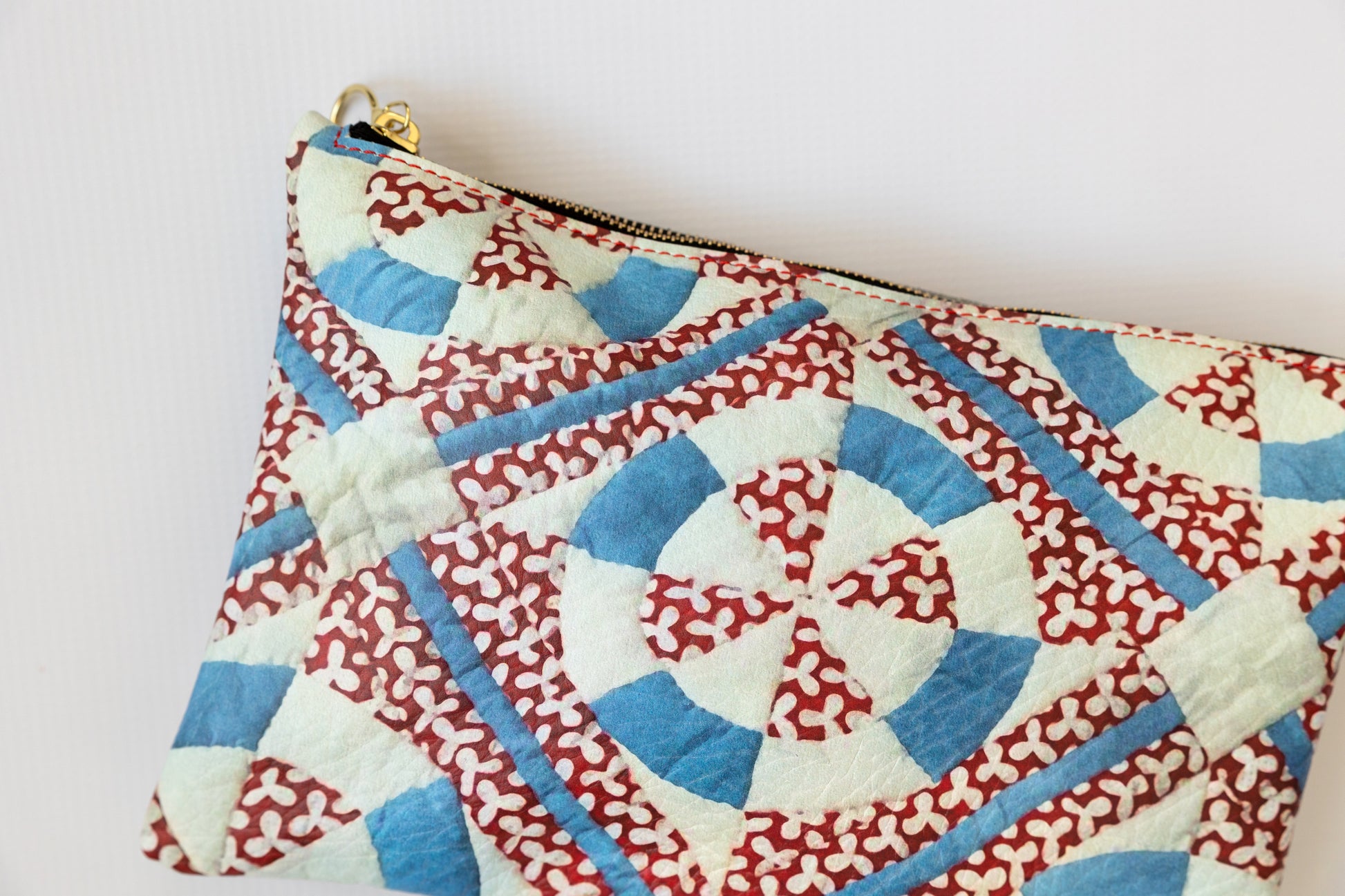 Fabric pouch with red, white, and blue geometric pattern on a light background