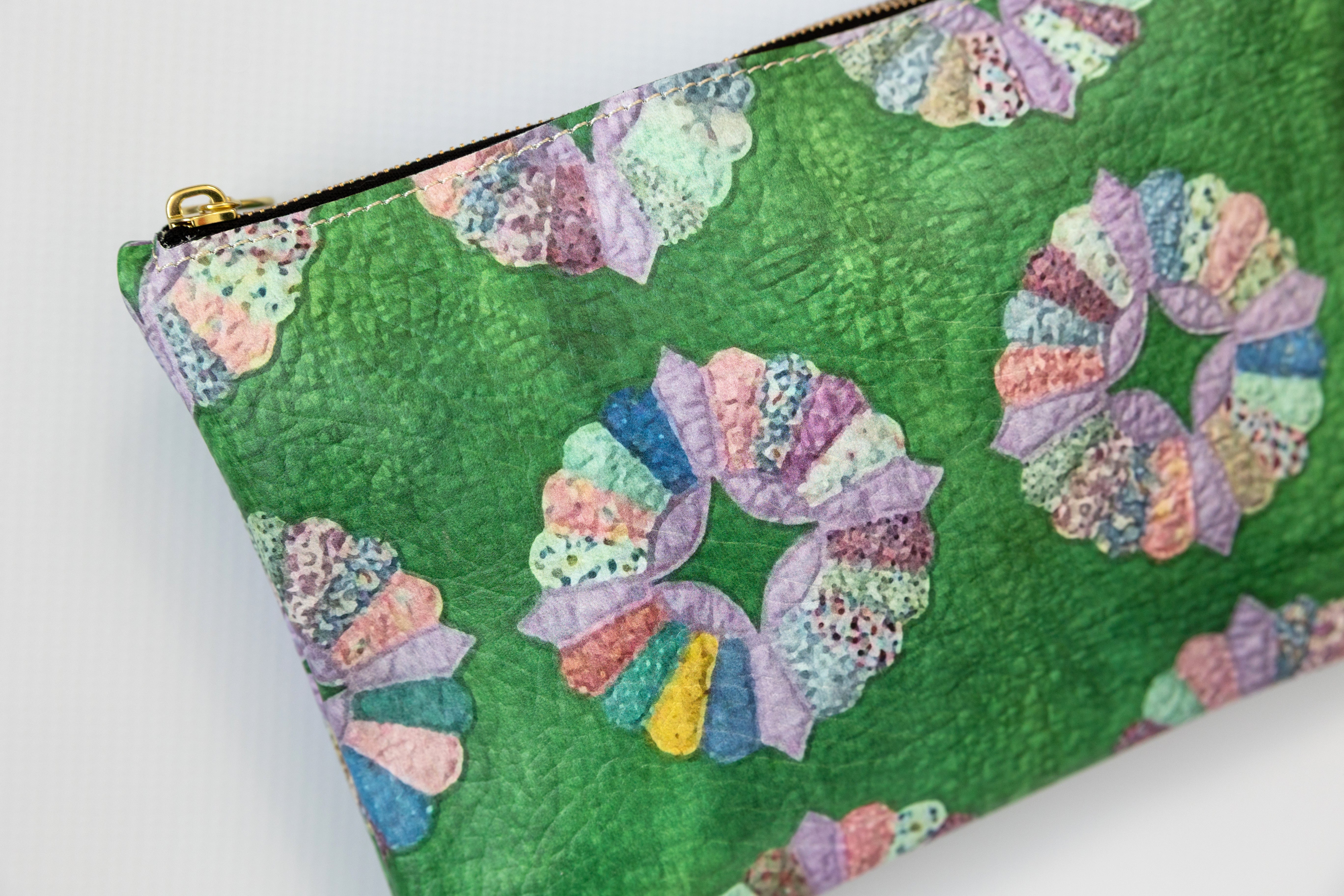 Green pouch with colorful floral patterns on a white background